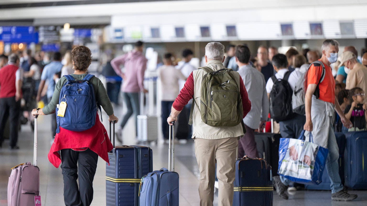 Passagiere warten auf dem Flughafen auf ihren Check-In.