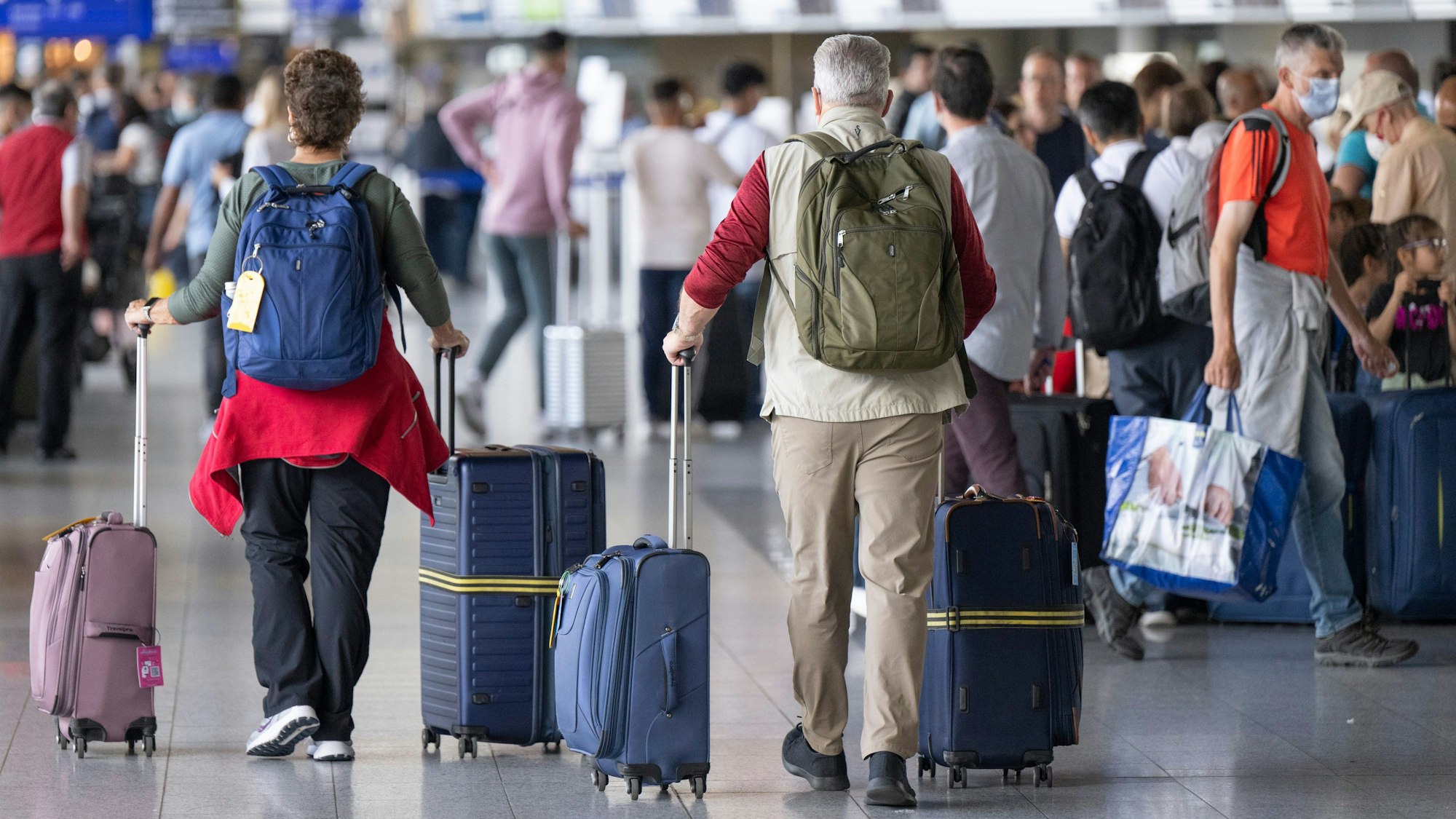 Passagiere warten auf dem Flughafen auf ihren Check-In.