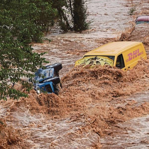 Zu sehen sind zwei Fahrzeuge in den Wasserfluten.