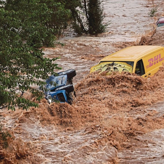 Zu sehen sind zwei Fahrzeuge in den Wasserfluten.