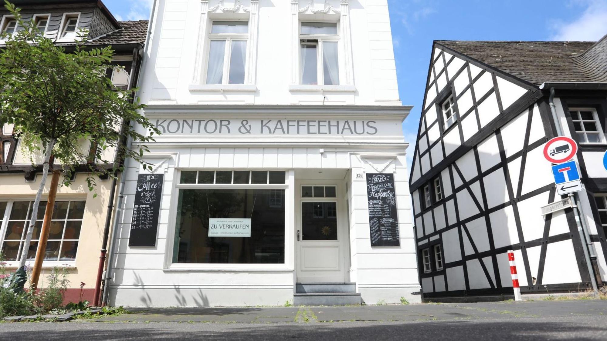 Ein Schild zu verkaufen hängt im Fenster eines Gebäudes, an dessen Fassade groß „Kontor & Kaffeehaus“ steht.