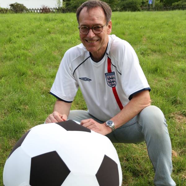 Ein Mann in einem Trikot der englischen Nationalmannschaft mit einem überdimensionalen Fußball