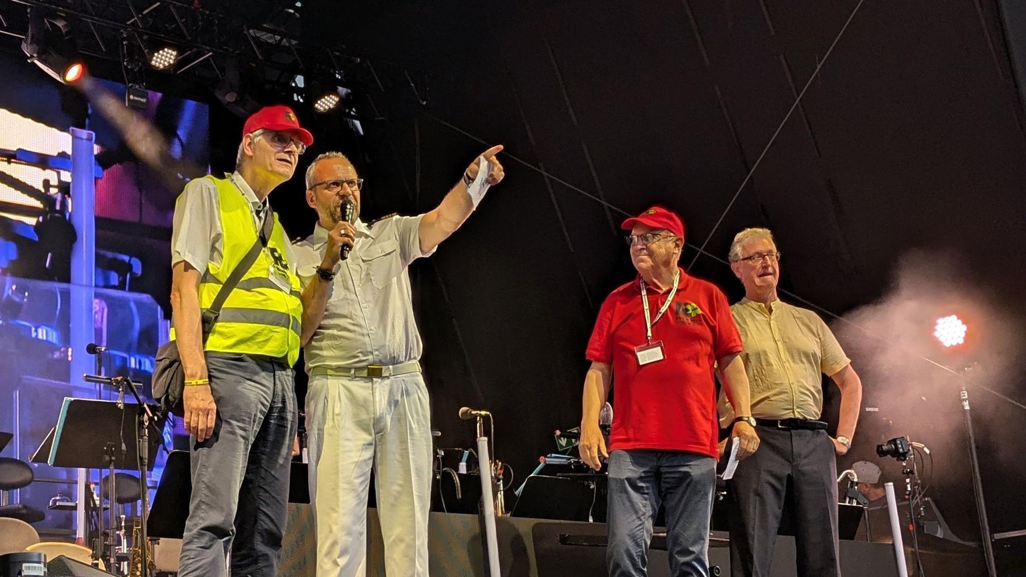 12. Juli 2024. Rheinbach. Benefizkonzert Big Band der Bundeswehr auf dem Himmeroder Wall: Der Moderator begrüßte zu Beginn des Konzertes Bürgermeister Ludger Banken, den Vorsitzenden und Gründer von "Rheinbach hilft", Alftred Eich, sowie Christoph Müller, Initiator des Musikprojektes "We Play 4 Ukraine", auf der Bühne (von links). Foto: Frank Engel-Strebel