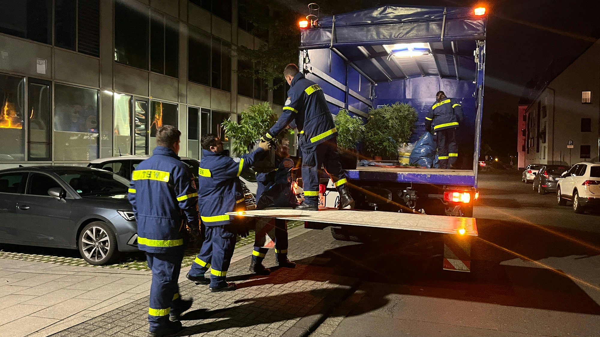 Einsatzkräfte des Technischen Hilfswerks (THW) entladen Cannabispflanzen und bringen sie in die Polizeiwache in Siegburg.