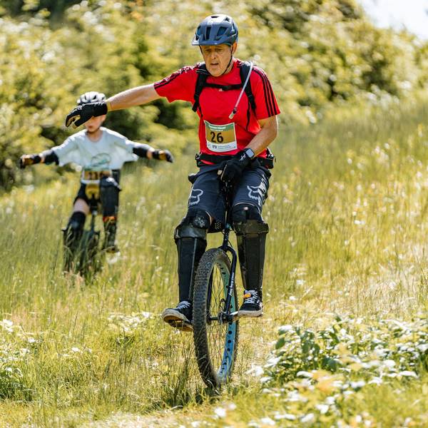 Zu sehen ist ein Einradfahrer bei einem Querfeldein-Rennen.