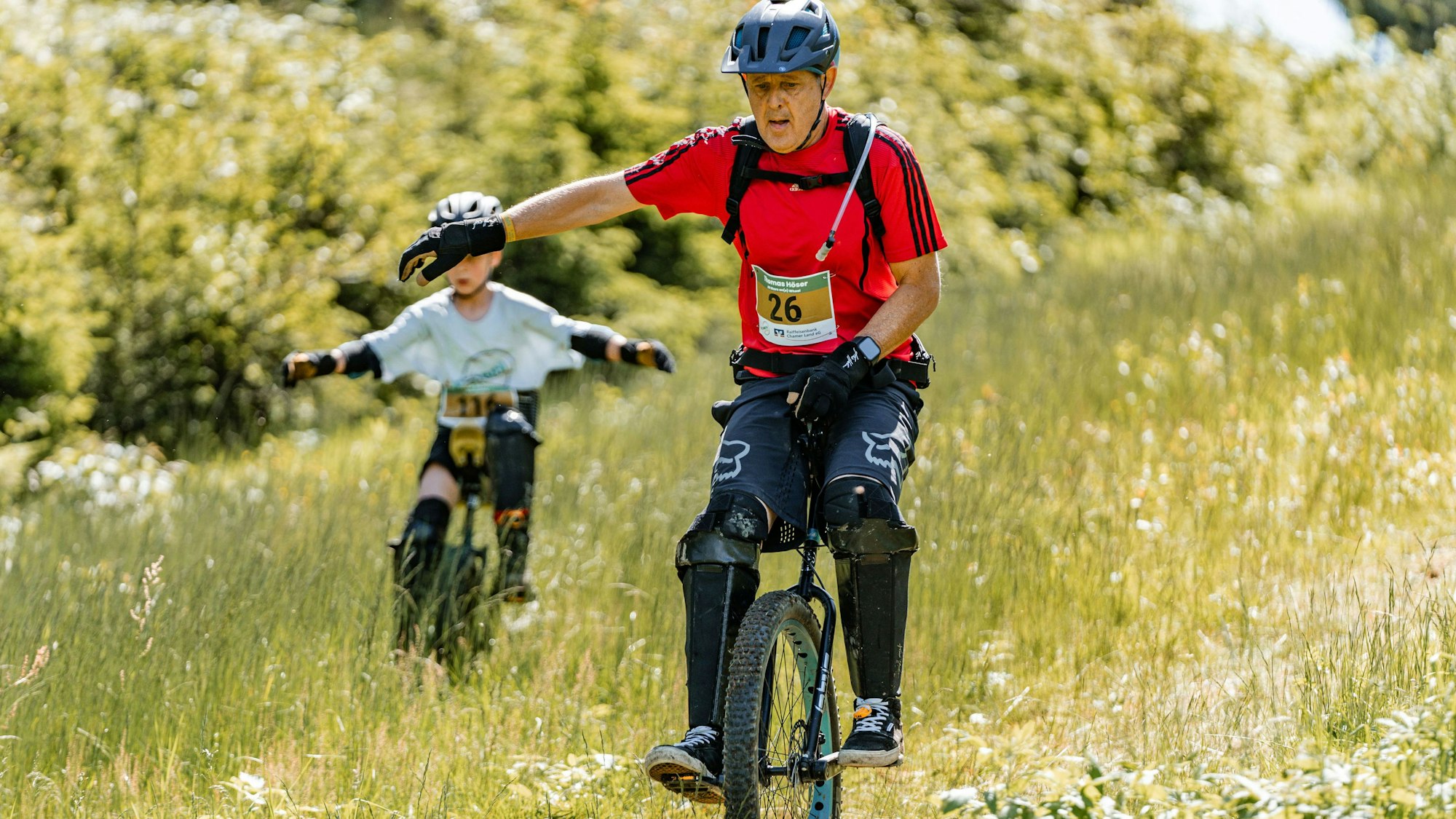 Zu sehen ist ein Einradfahrer bei einem Querfeldein-Rennen.