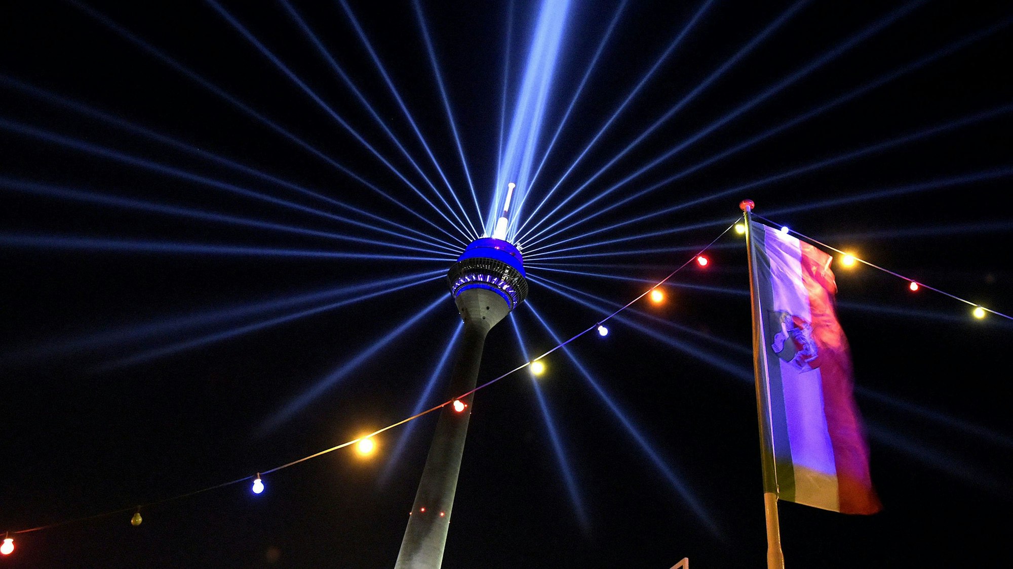Laserlichter strahlen vom Düsseldorfer Funkturm in die Umgebung.