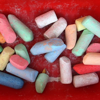 Bunte Straßenmalkreide liegt im Anhänger eines Bobby-Cars.