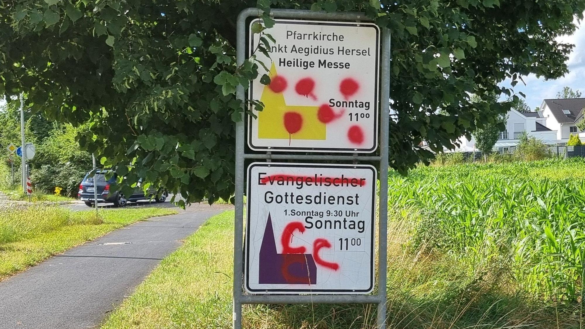 12. Juli 2024. Bornheim/Bonn. Wie hier in Hersel wurden auch in Auerberg Hinweisschilder der evangelischen und katholischen Kirchen beschmiert. Foto: Frank Engel-Strebel