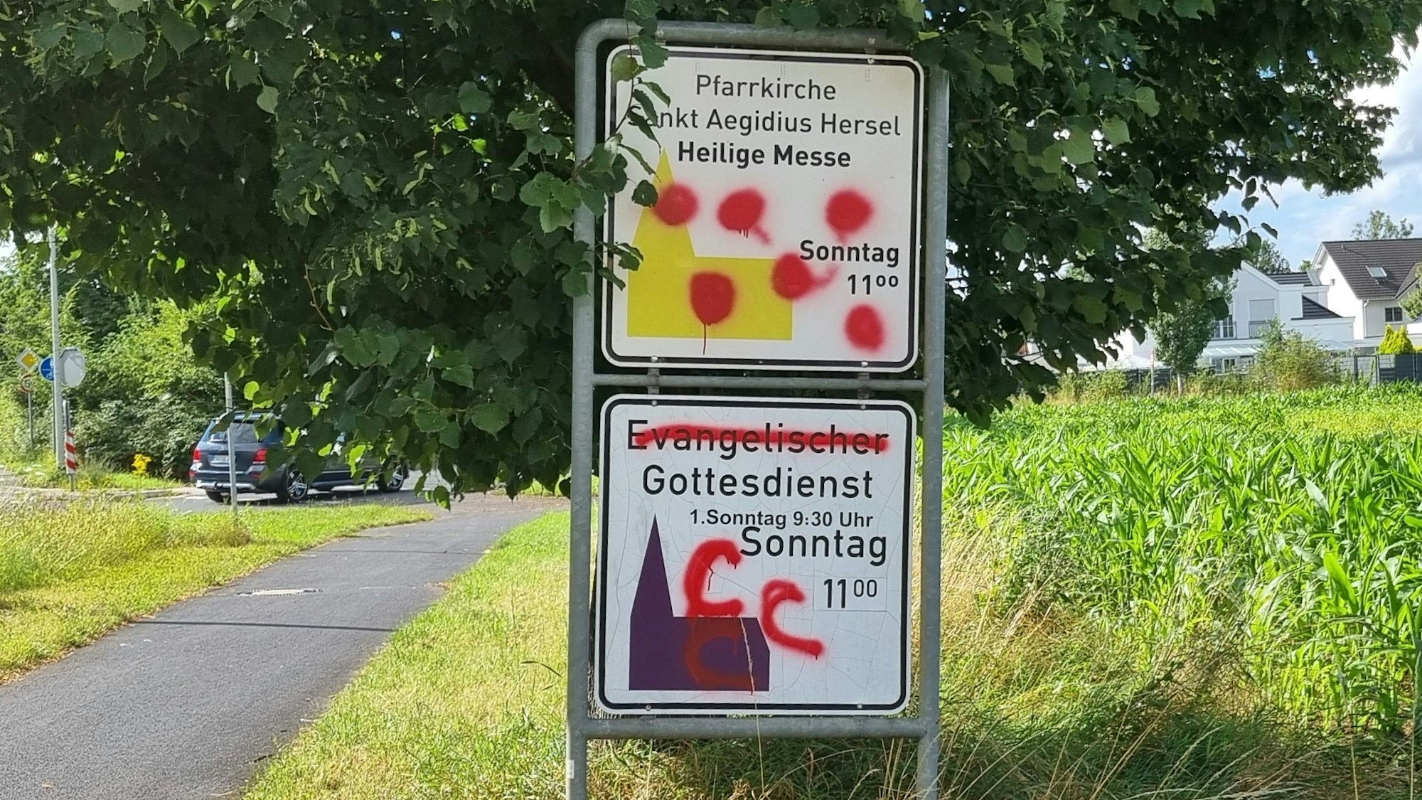 12. Juli 2024. Bornheim/Bonn. Wie hier in Hersel wurden auch in Auerberg Hinweisschilder der evangelischen und katholischen Kirchen beschmiert. Foto: Frank Engel-Strebel