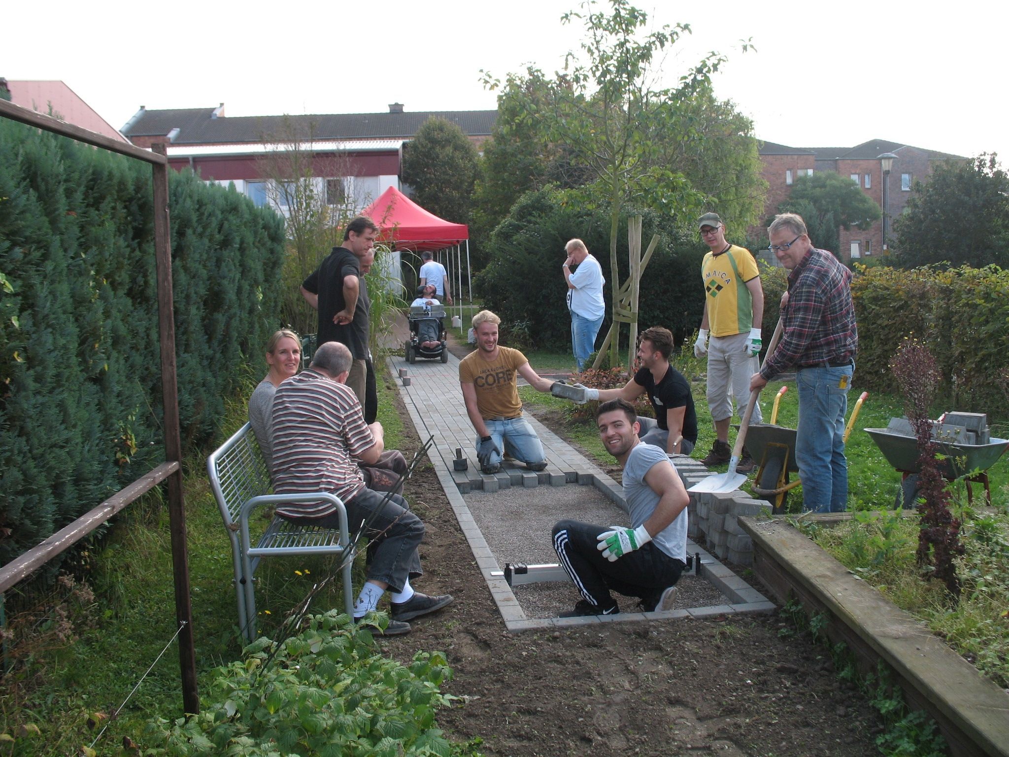 Eine Projektgruppe legt im Rahmen des Freiwilligentags für das Haus „Lebenshilfe“ in Sülz einen Pflasterweg an.