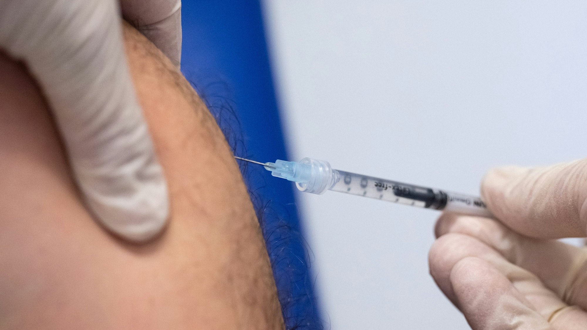 Eine Detailaufnahme zeigt, wie eine Spritze in einen haarigen Oberarm sticht. (Archivbild)