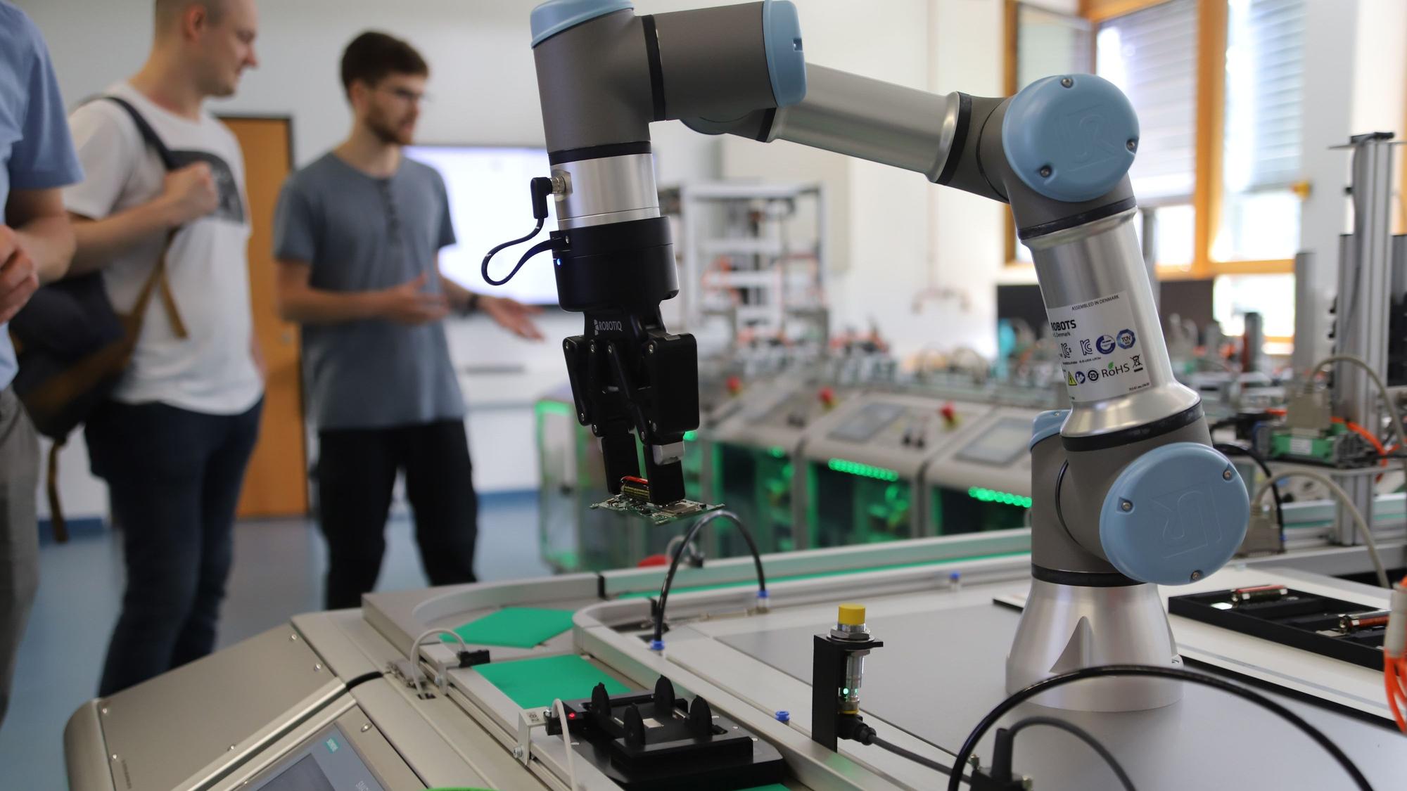 Ein Roboterarm steht am Ende einer vollautomatischen Produktionsstraße.