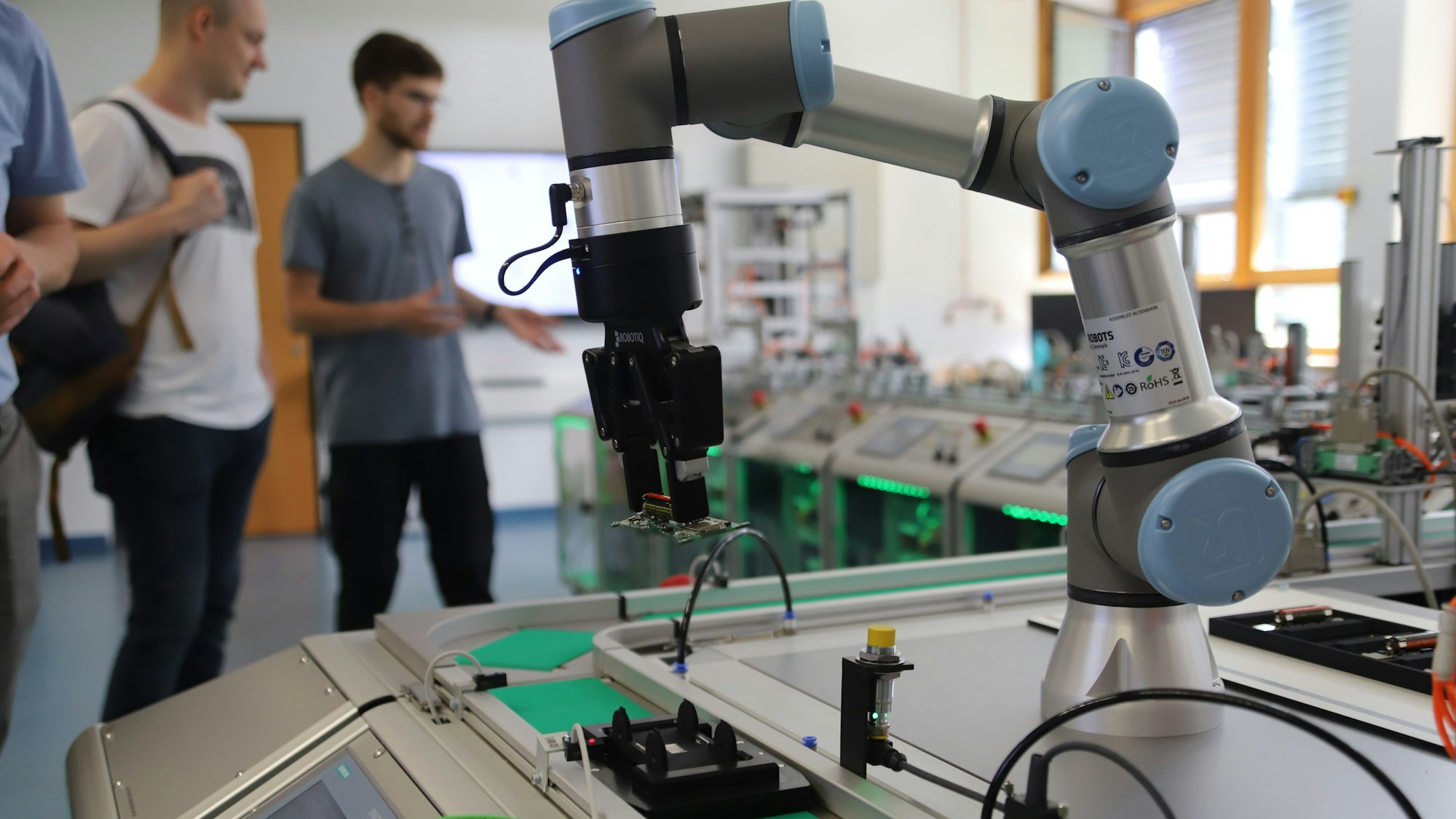 Ein Roboterarm steht am Ende einer vollautomatischen Produktionsstraße.