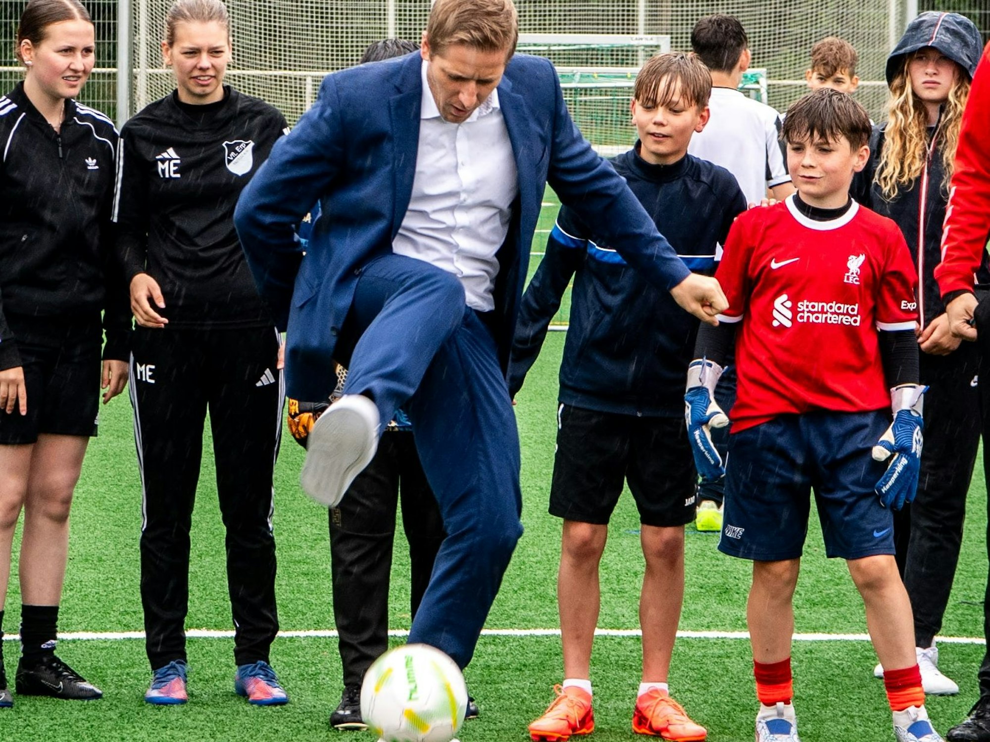 Das Bild zeigt Landrat Markus Ramers, wie er im Anzug samt weißem Hemd einen Fußball jongliert.