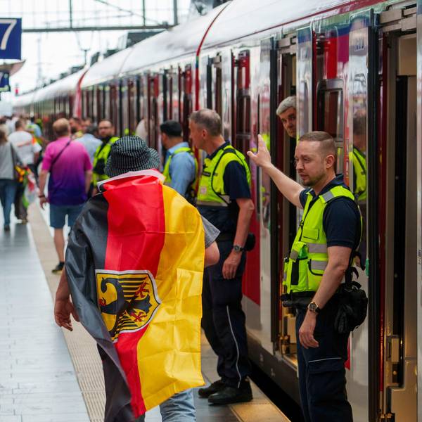 Sicherheitspersonal der Bahn weisst einem deutschen Fan den Weg zu einem freien Abteil, ganz am Ende des Zuges. (Archivbild)