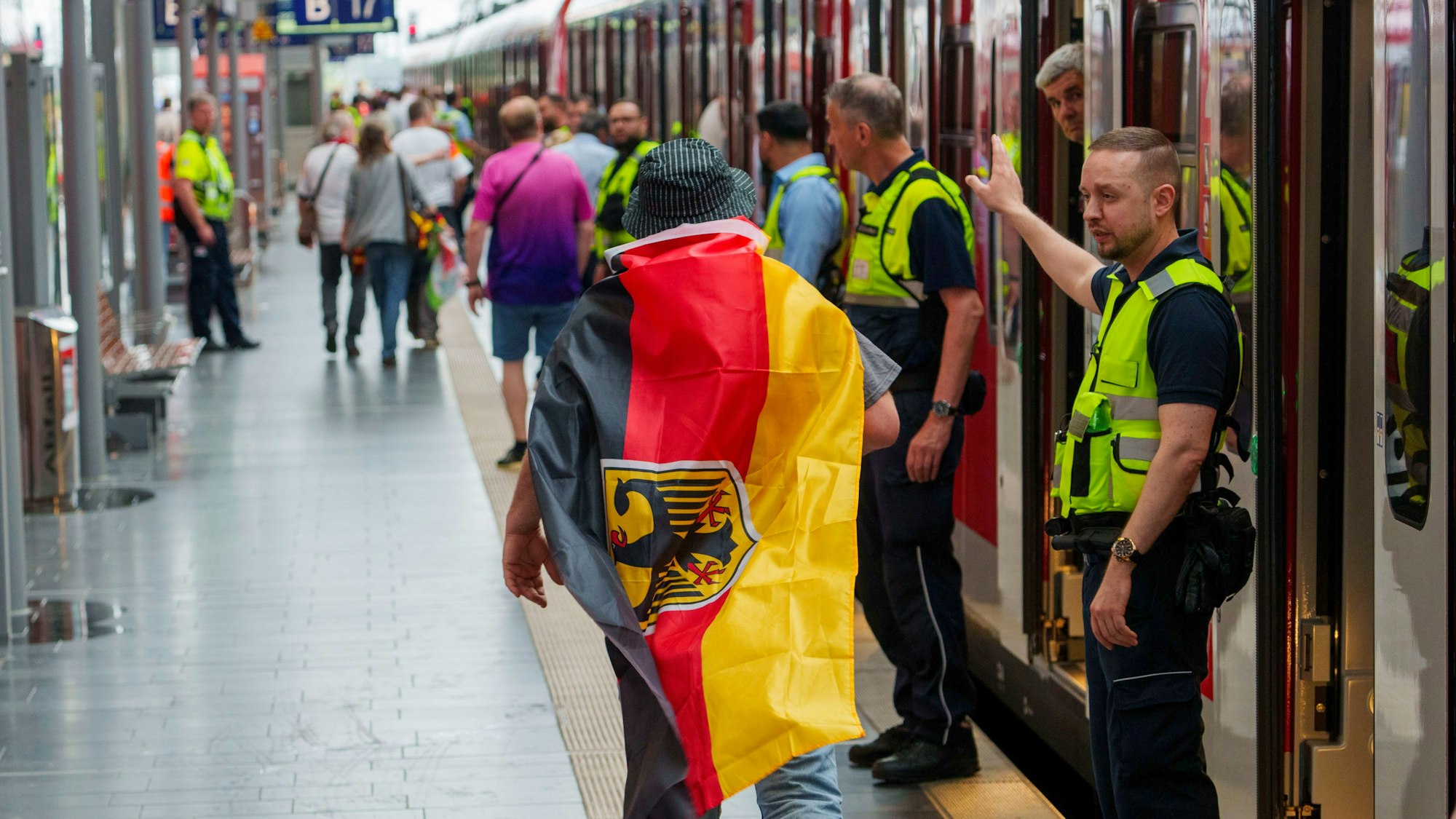 Sicherheitspersonal der Bahn weisst einem deutschen Fan den Weg zu einem freien Abteil, ganz am Ende des Zuges. (Archivbild)