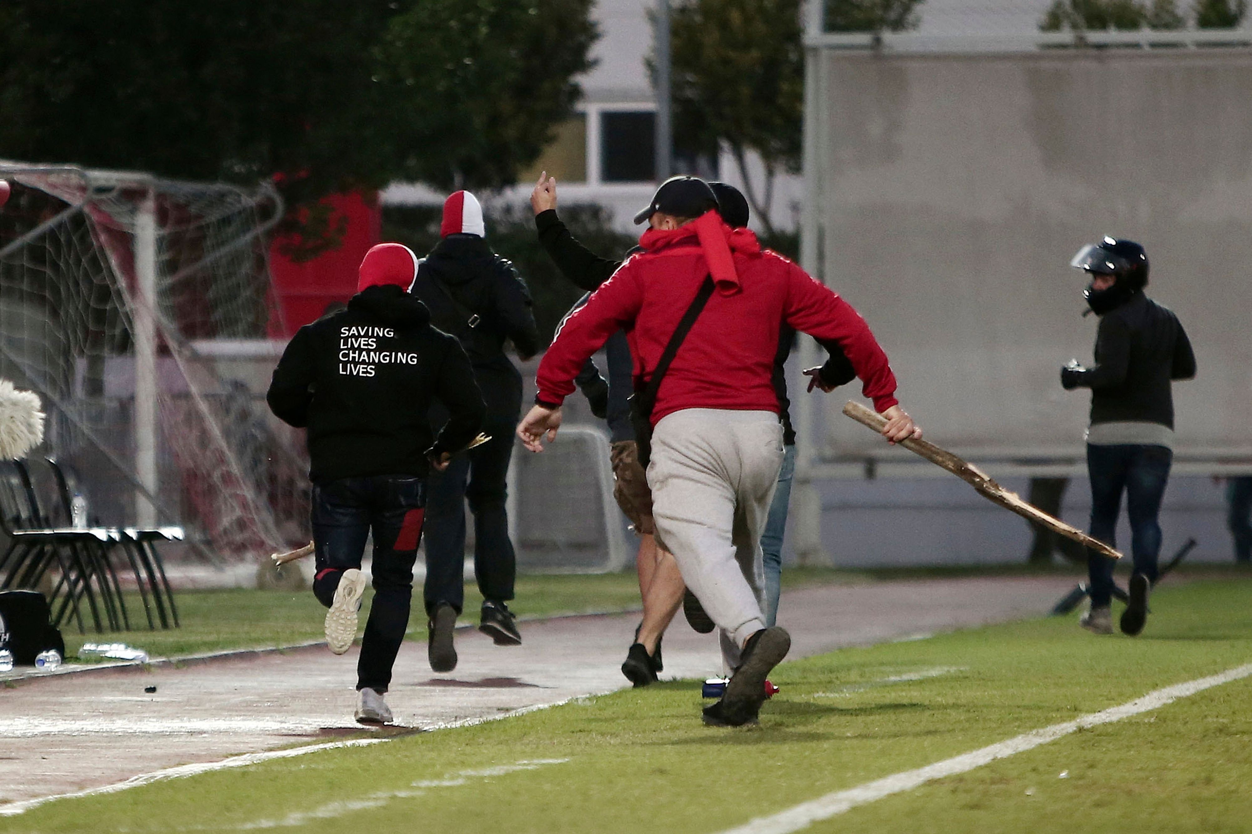 Vermummte Fans stürmen aus einem Stadion, nach einem Angriff auf Bayern München-Fans während eines U19-Fußballspiels zwischen Olympiakos Piräus und dem FC Bayern München.