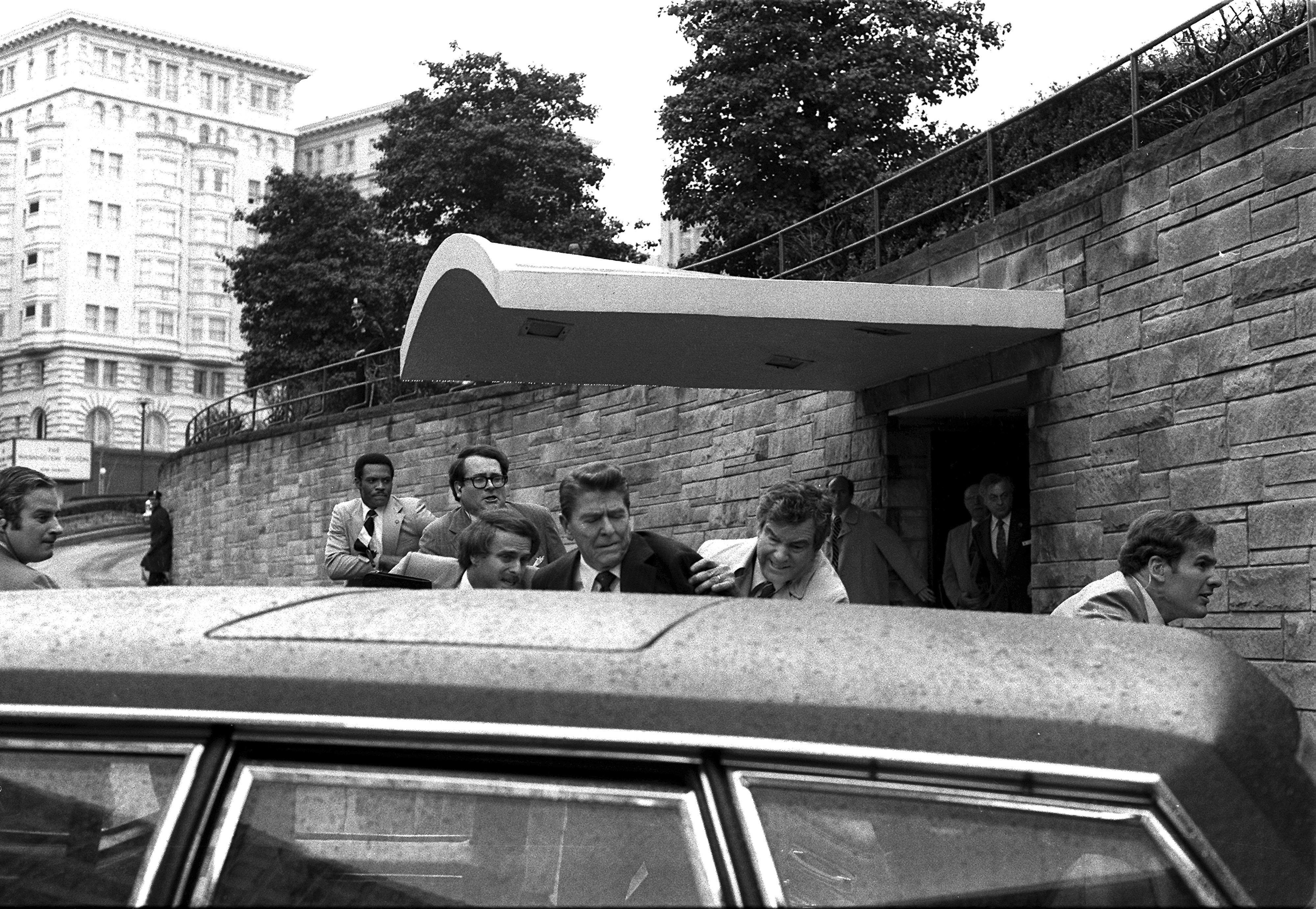 US-Präsident Ronald Reagan wird am 30. März 1981 von Geheimdienstagenten in die Präsidentenlimousine geschoben, nachdem er vor einem Hotel in Washington angeschossen wurde.