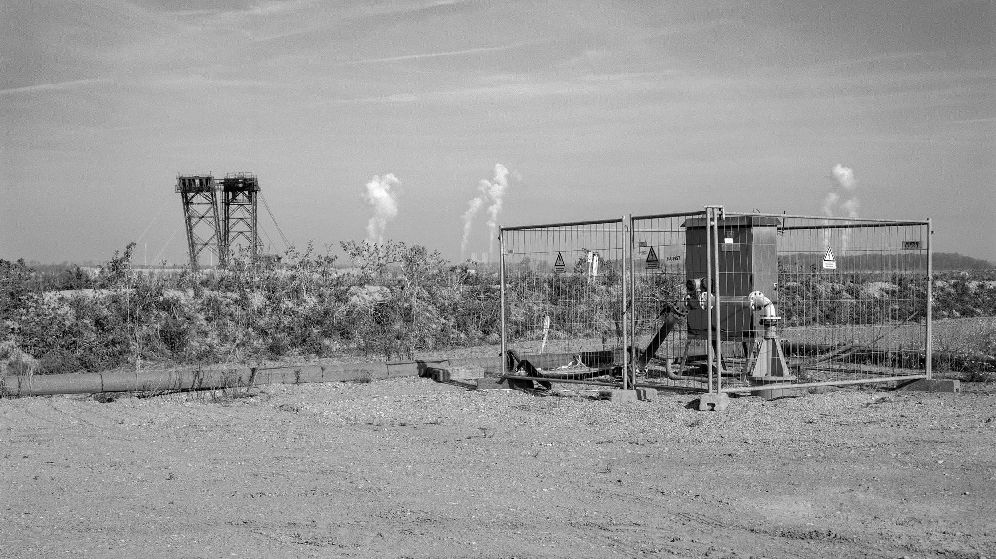 Eine Sümpfungsanlage, im Hintergrund ein Schaufelradbagger.