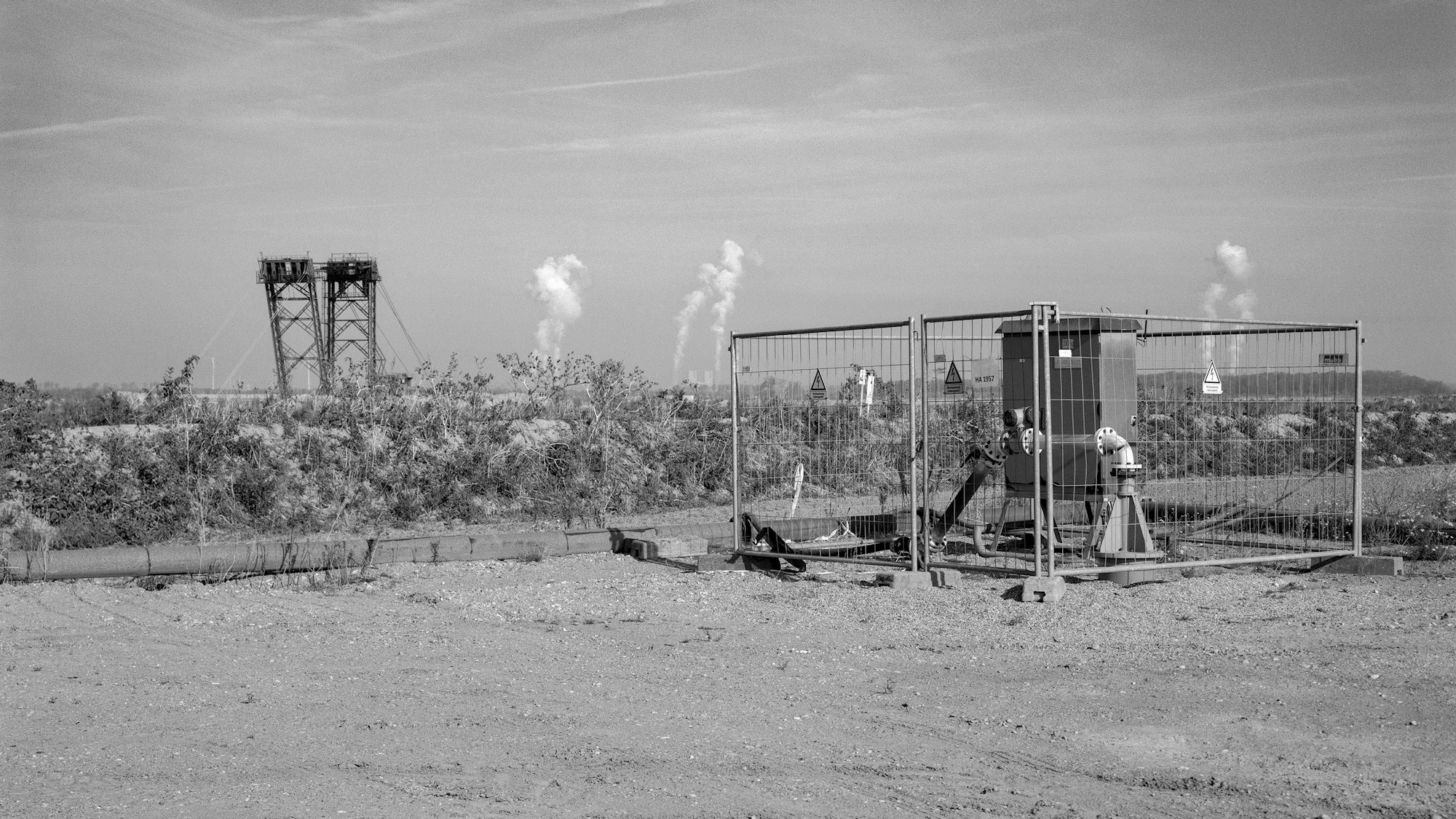 Eine Sümpfungsanlage, im Hintergrund ein Schaufelradbagger.
