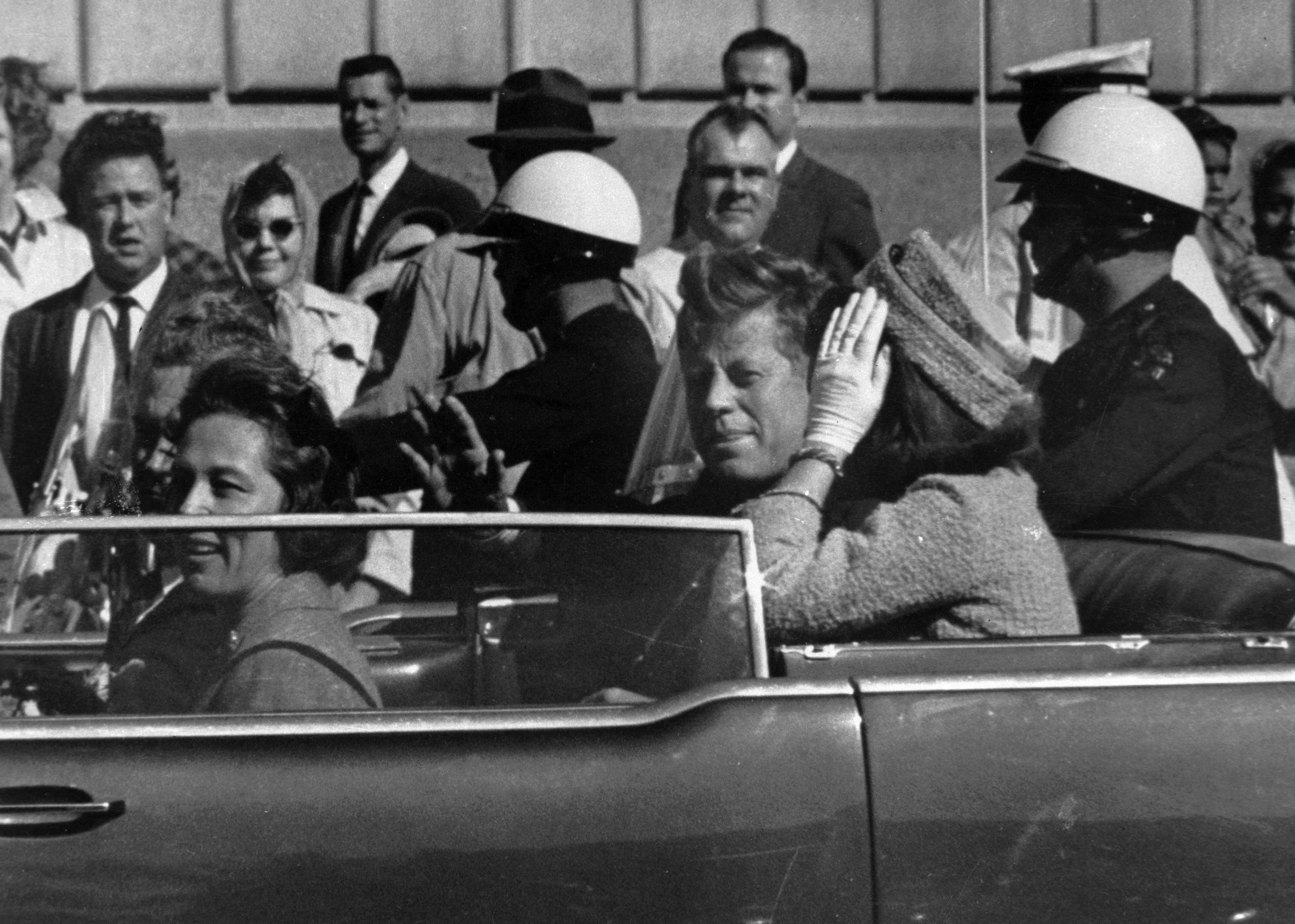 Kurz vor seiner Ermordung sitzt der damalige US-Präsident John F. Kennedy am 22.11.1963 in Dallas (USA) zusammen mit seiner Frau Jacqueline (r), Nellie Connally (l) und ihrem Mann, dem Gouverneur von Texas, John Connally, in einer offenen Limousine. (Archivbild)