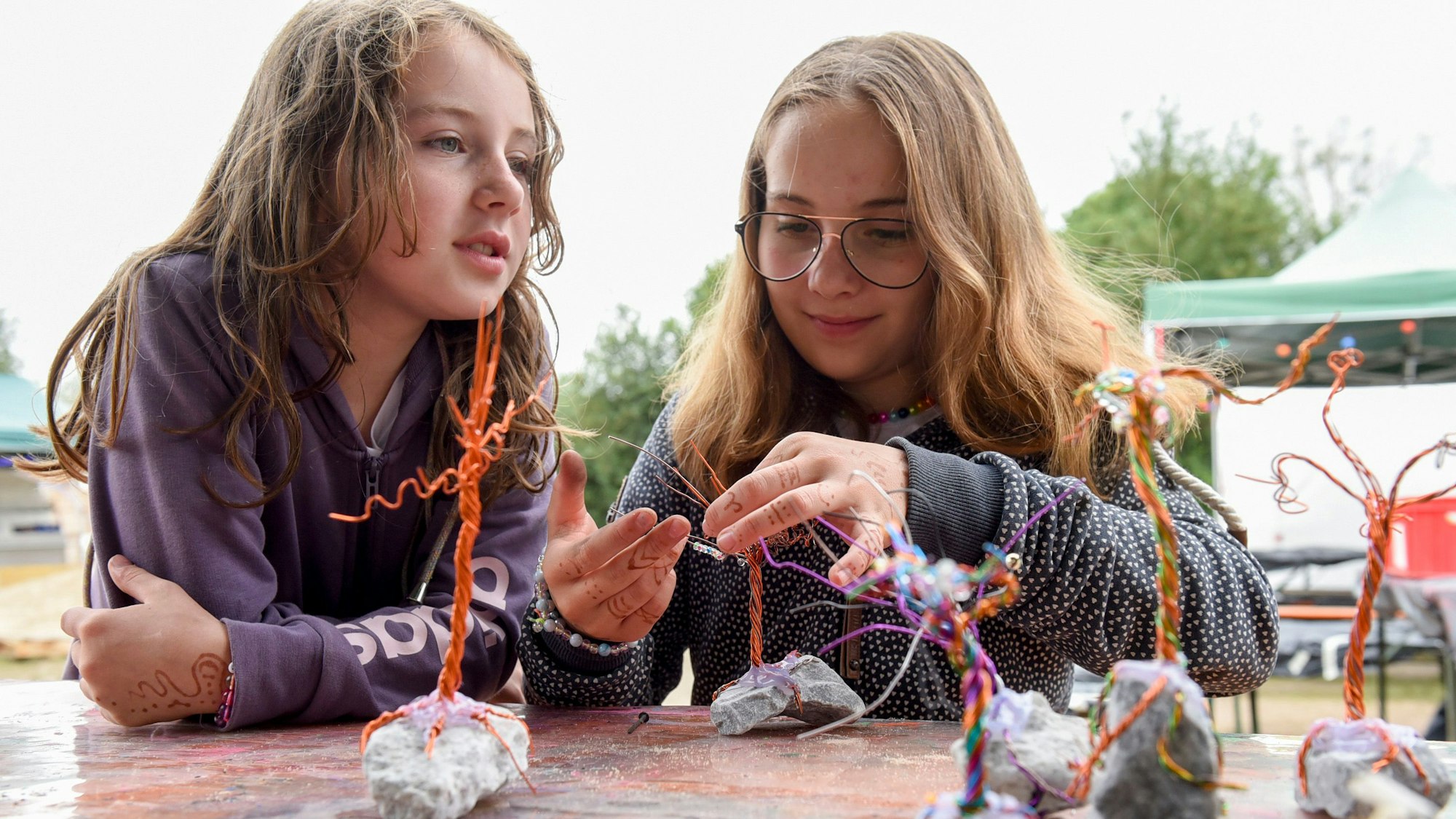 Zwei Mädchen bauen einen Pfennigbaum.