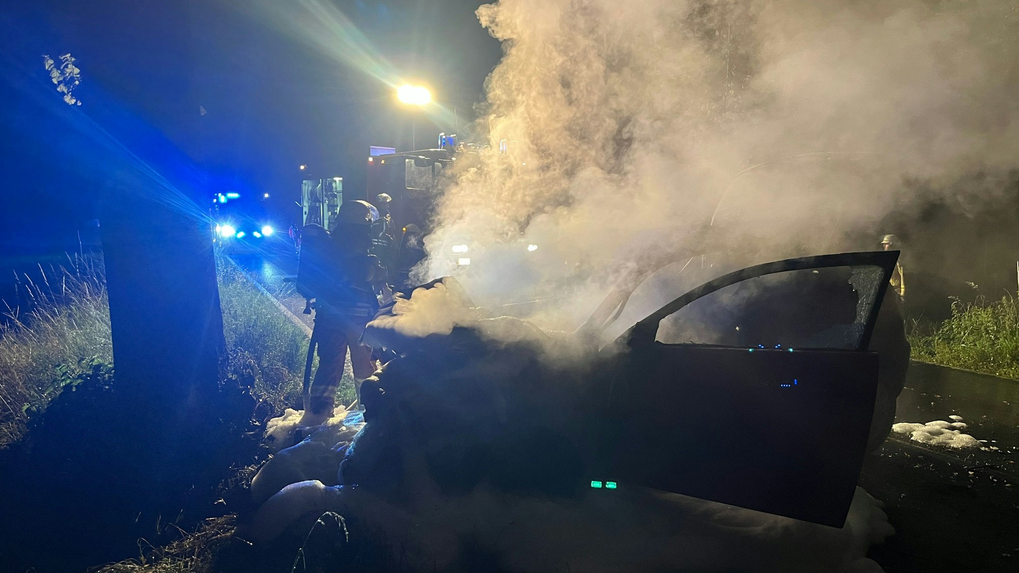 Eine Feuerwehrfrau löscht mit wenig Wasser.