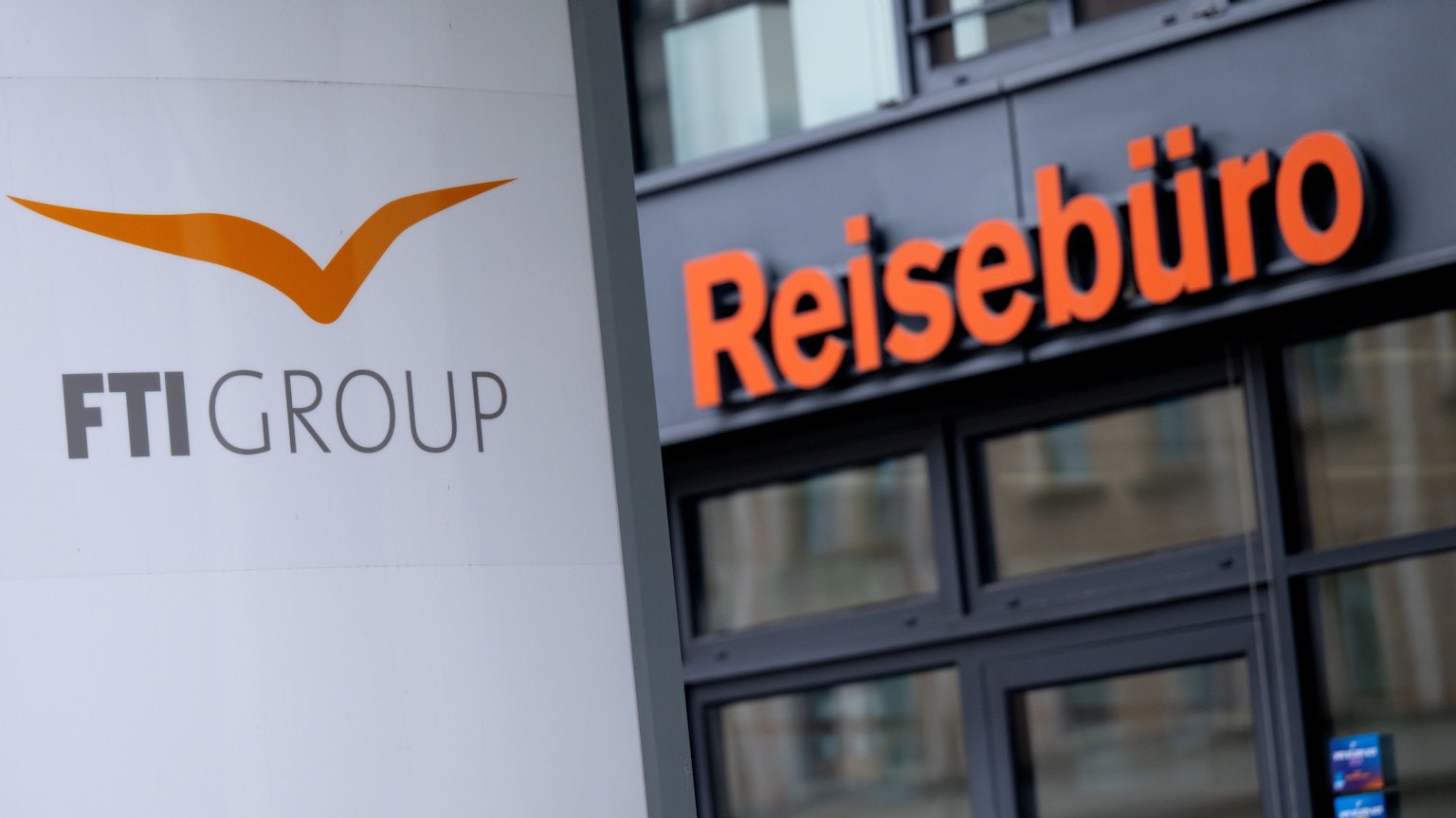 Ein Schild und Reisebüro der FTI-Group