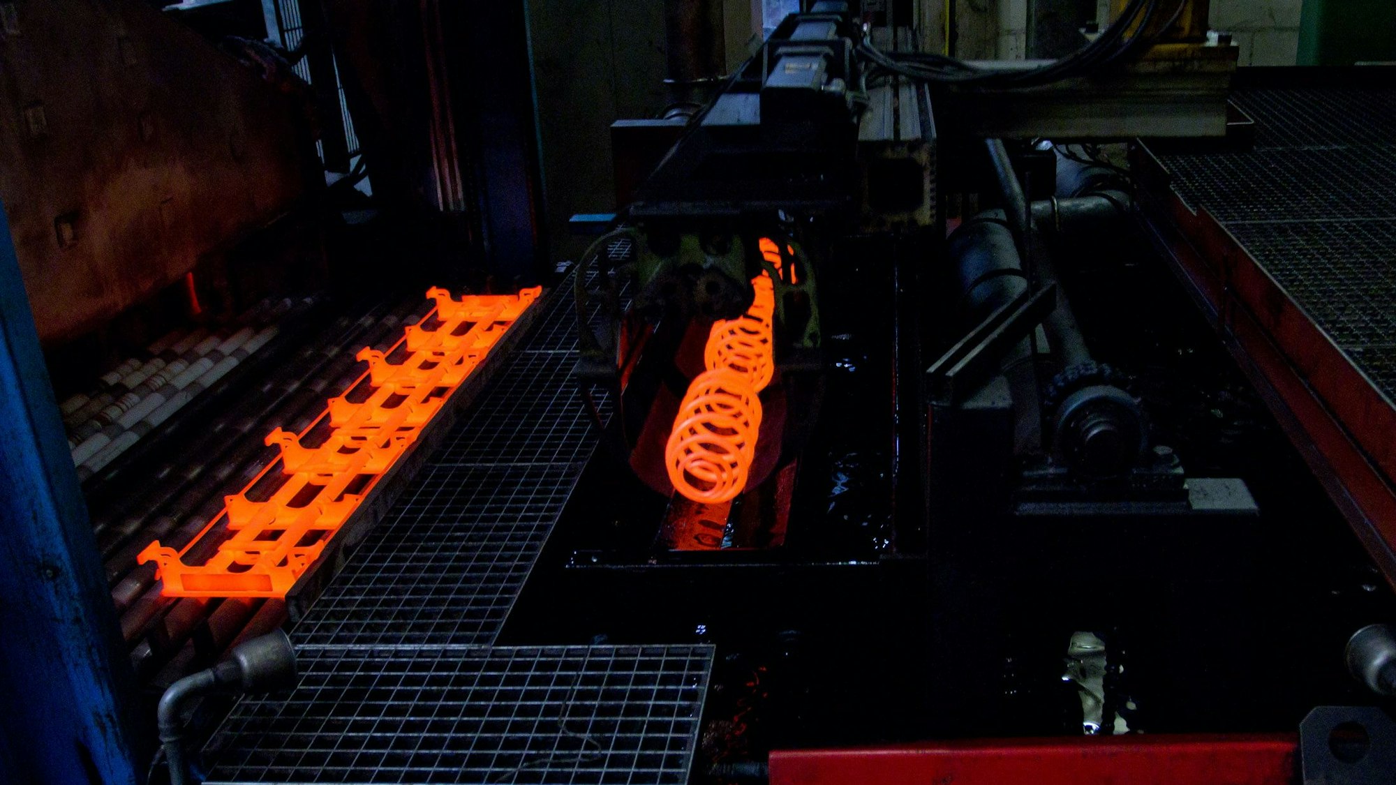 Rotglühende Federn in einem Härteofen bei Ahle.