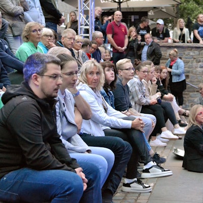 Zahlreiche Menschen sitzen gemeinsam mit Bürgermeisterin Sabine Preiser-Marian auf der Freitreppe zur Erft in Bad Münstereifel.