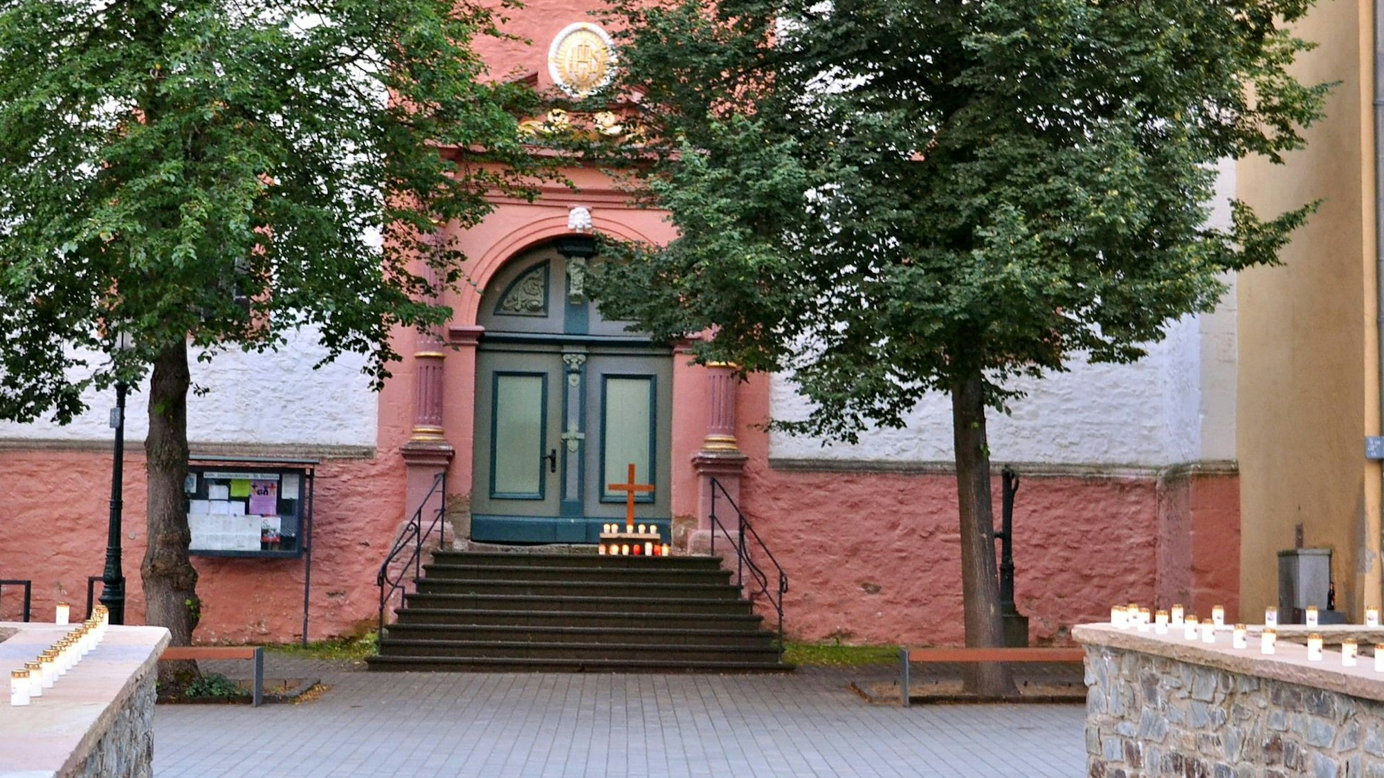 Zum Gedenken an die Opfer der Flutkatastrophe 2021 stehen vor der Jesuitenkirche in Bad Münstereifel zahlreiche Kerzen.