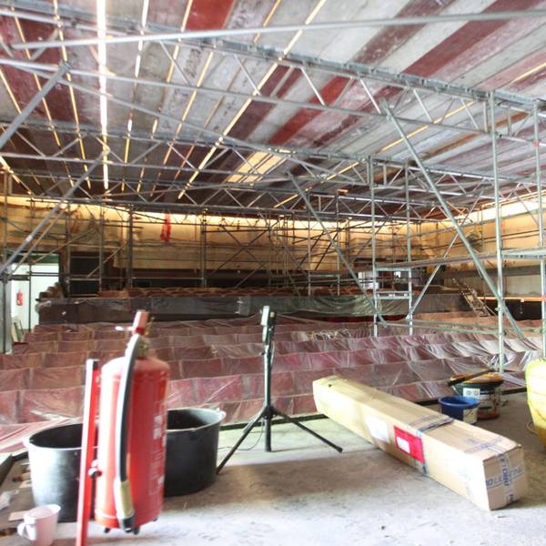 Blick in den Kino-Saal mit abgedeckten Stuhlreihen und komplett eingerüsteten Wänden und Decke.