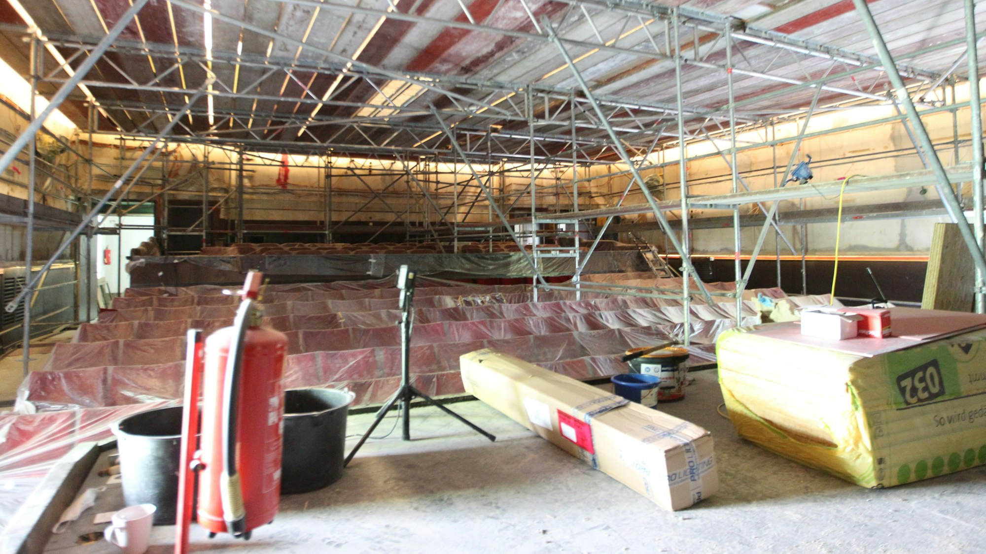 Blick in den Kino-Saal mit abgedeckten Stuhlreihen und komplett eingerüsteten Wänden und Decke.