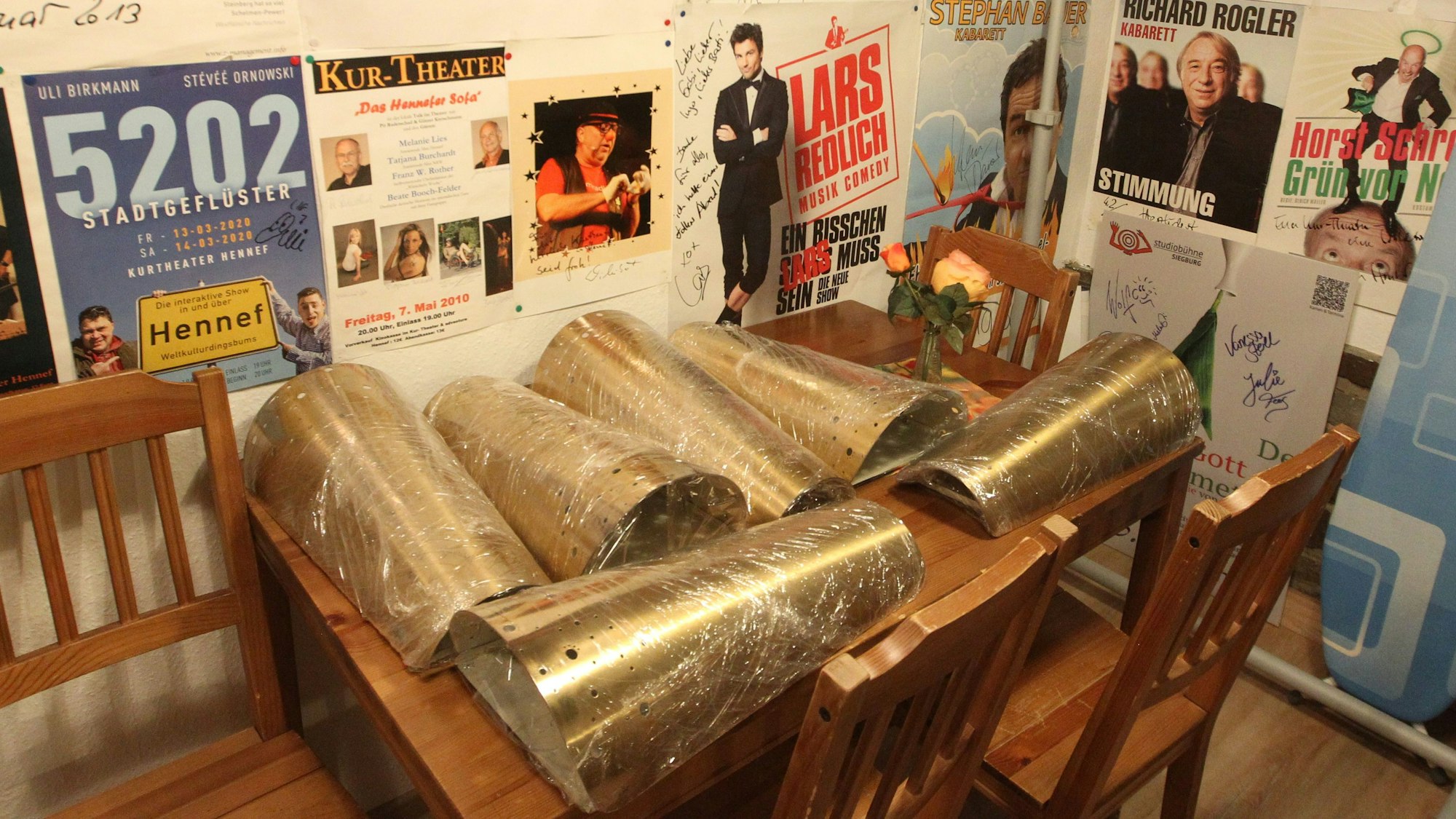 Auf einem Tisch liefen sechs längliche Messing-Lampenschirme.