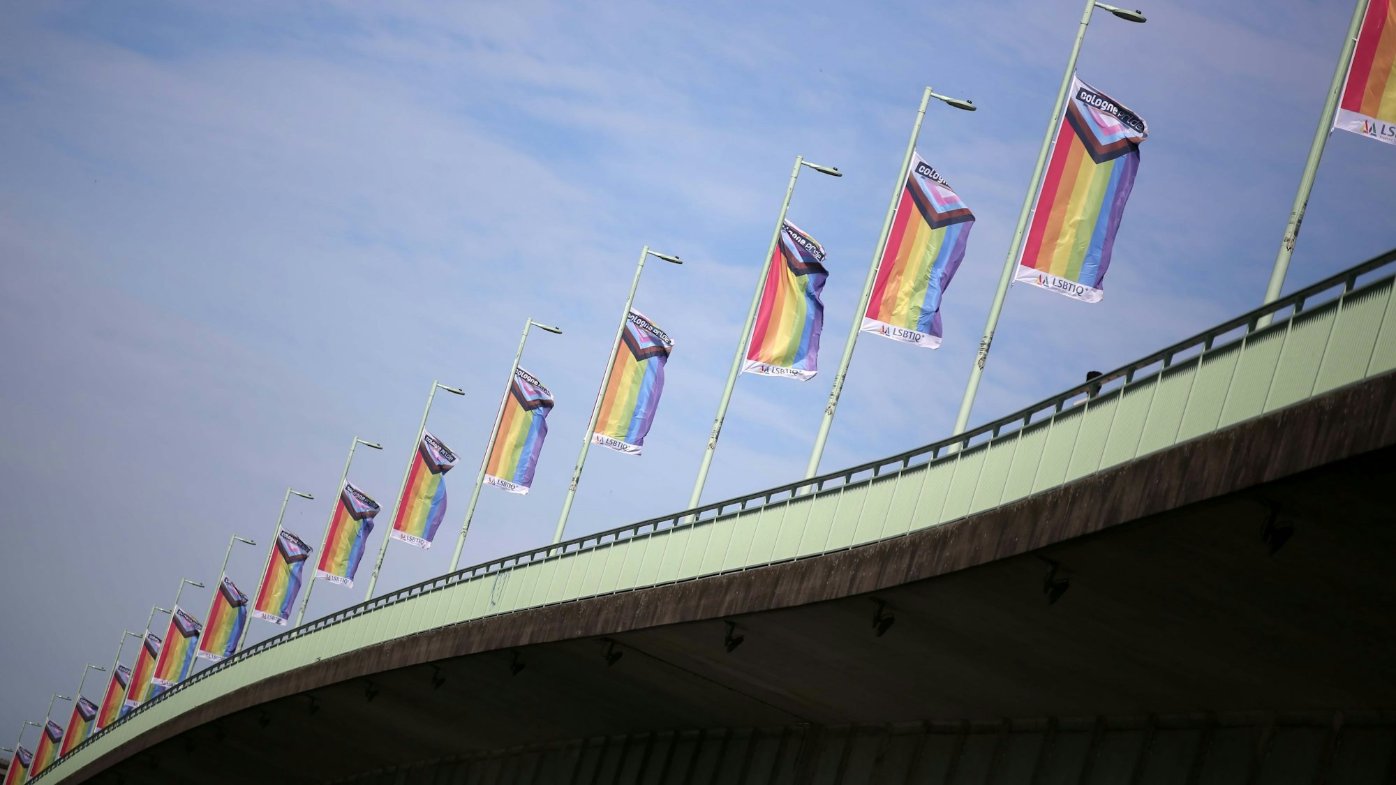 Viele Regenbogenfahnen auf einer Brücke.