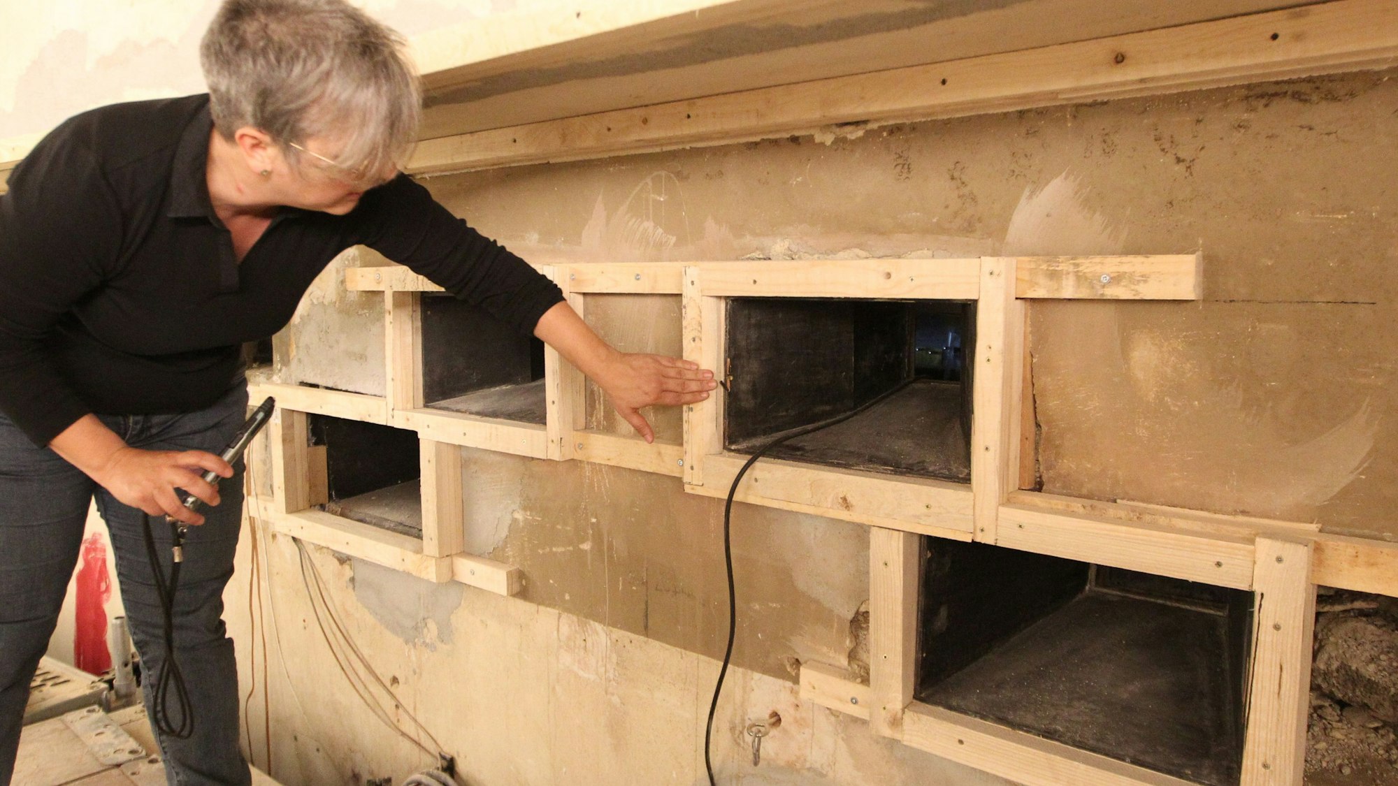 Architektin Susanne Dittrich zeigt die Wandluken für die Filmprojektoren.