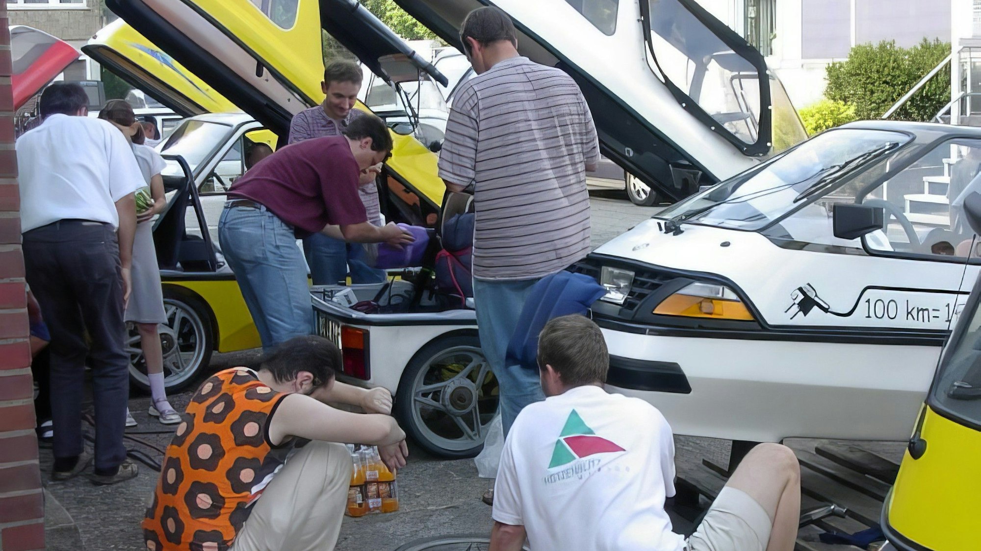 Mehrere Männer stehen zwischen den Wagen, einige sind mit der Technik in einem Auro zugange.
