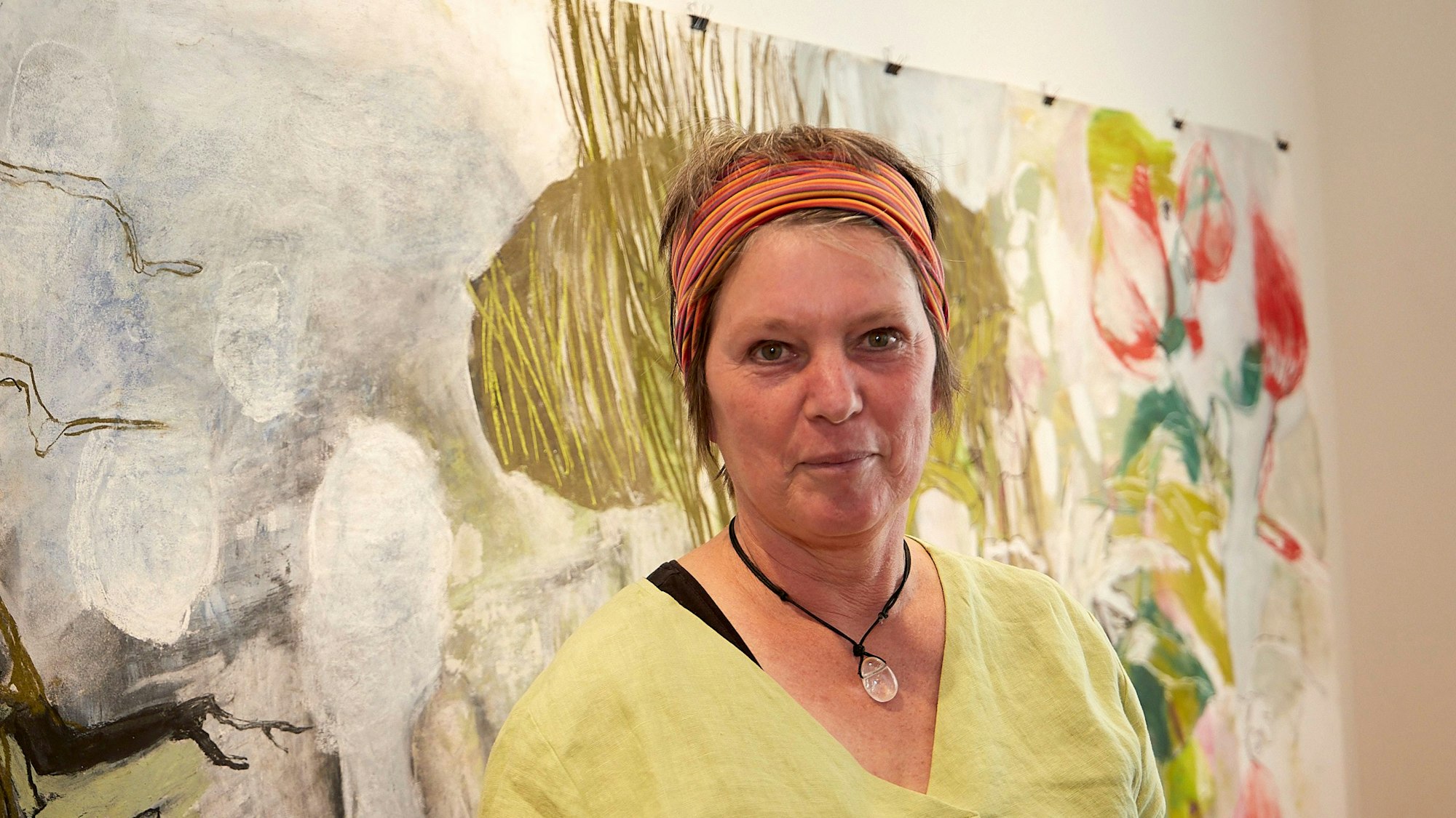 Die Malerin Mimi van Bindsbergen steht vor einem ihrer Bilder.