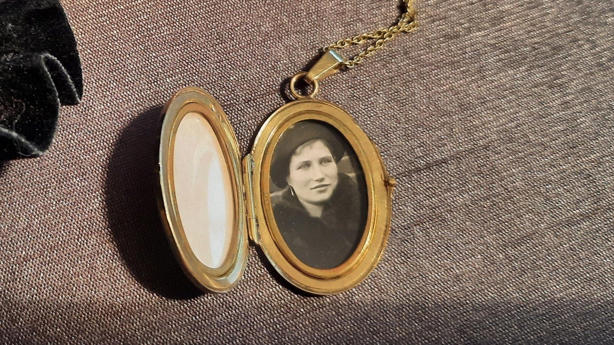 Ein Medaillon mit einem alten Foo einer jungen Frau drin.