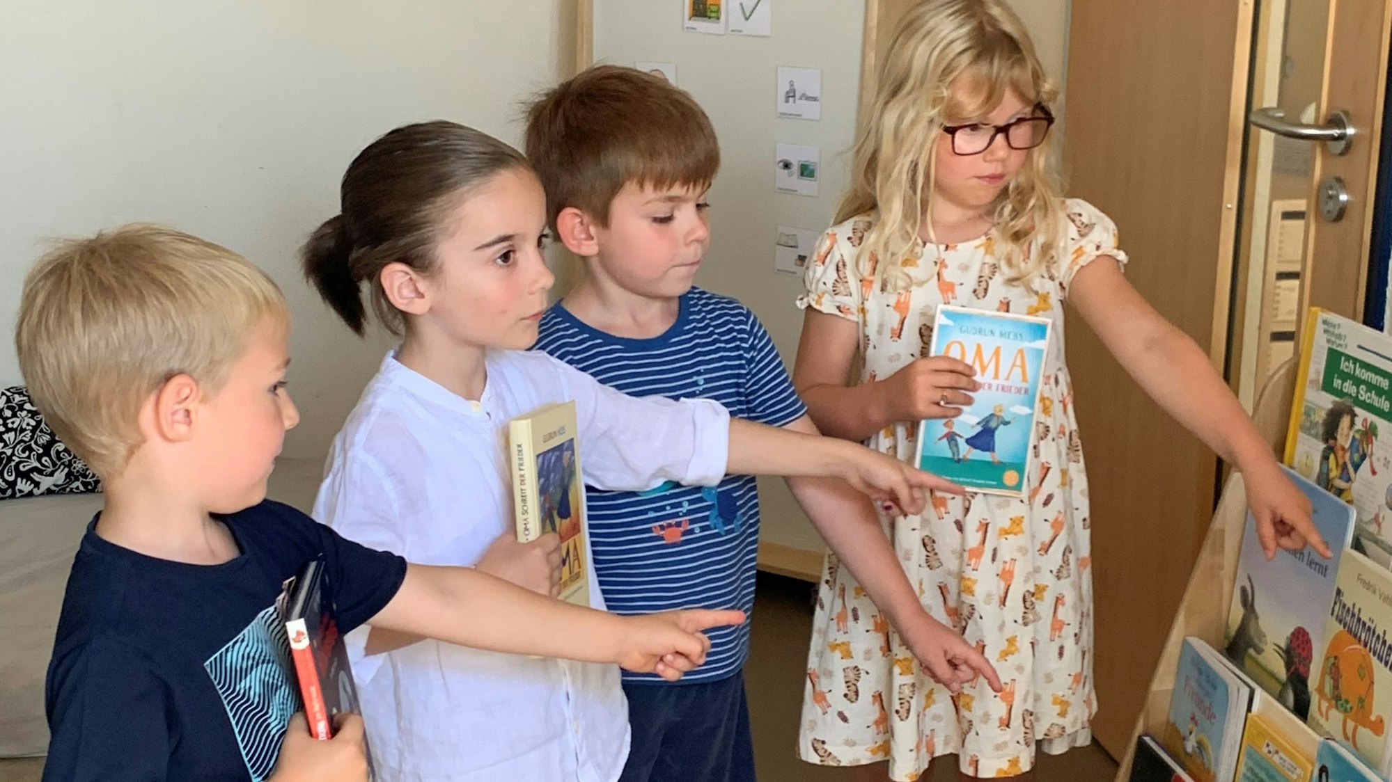 Kinder haben sich bereits Bücher ausgesucht.