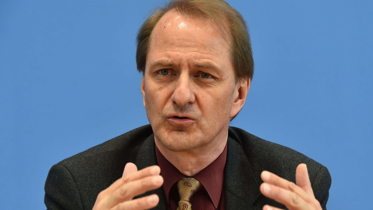 Dirk Messner, UBA-Präsident, gestikuliert vor einem einfarbigen Hintergrund. (Archivbild)