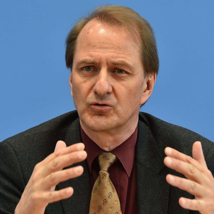 Dirk Messner, UBA-Präsident, gestikuliert vor einem einfarbigen Hintergrund. (Archivbild)