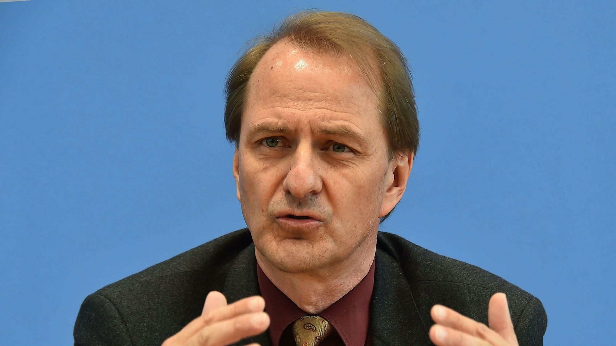 Dirk Messner, UBA-Präsident, gestikuliert vor einem einfarbigen Hintergrund. (Archivbild)