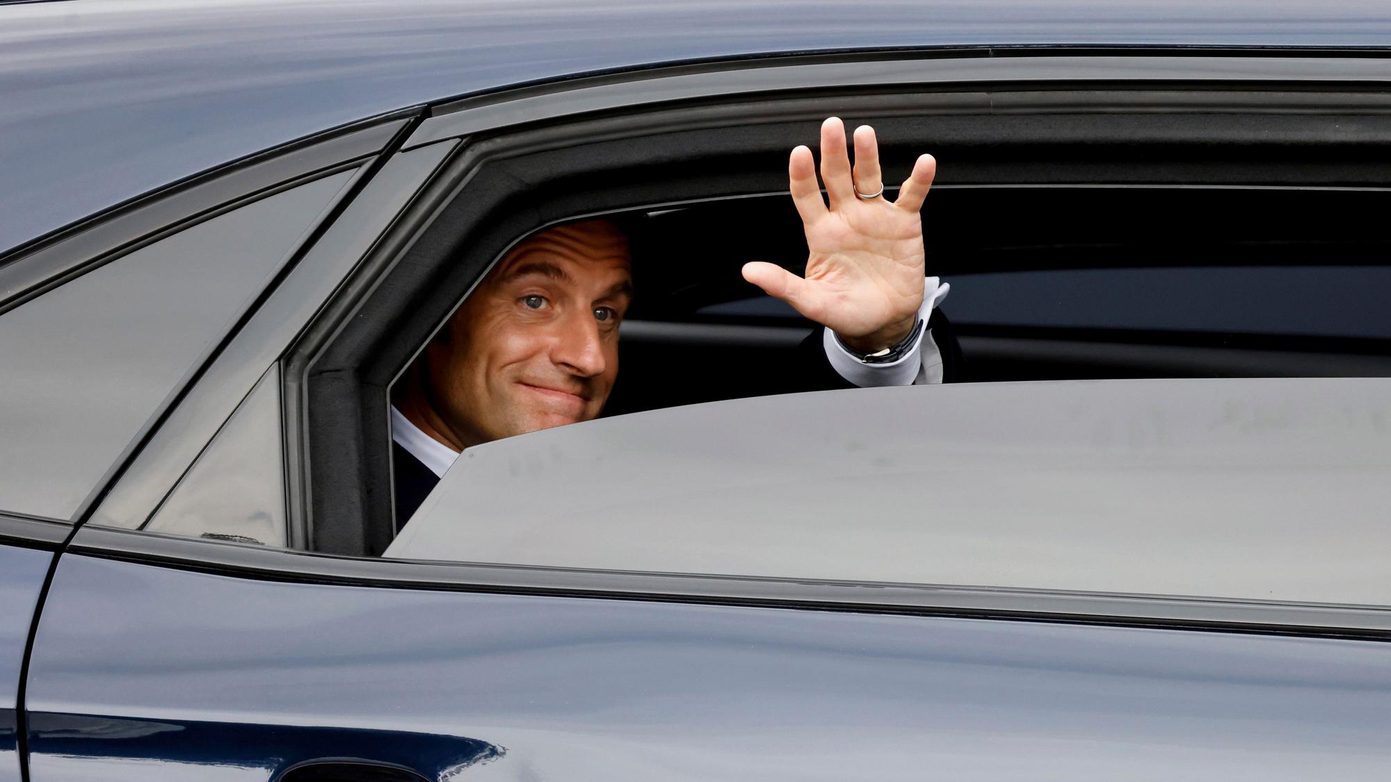 14.07.2024, Frankreich, Paris: Der französische Präsident Emmanuel Macron verlässt die Stadt nach der Teilnahme an der Militärparade zum Tag der Bastille auf der Avenue Foch.
