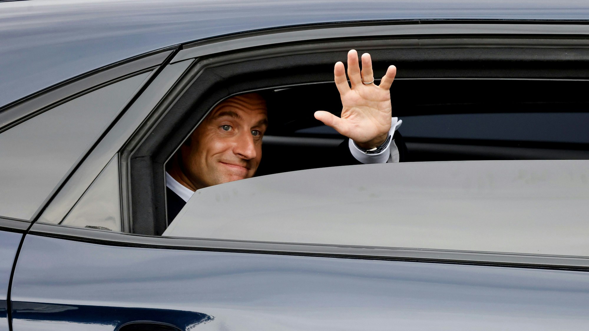 14.07.2024, Frankreich, Paris: Der französische Präsident Emmanuel Macron verlässt die Stadt nach der Teilnahme an der Militärparade zum Tag der Bastille auf der Avenue Foch.