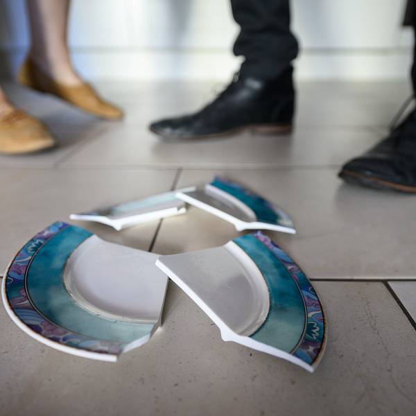 Ein Mann und eine Frau stehen hinter einem zerbrochenen Teller in einer Küche.