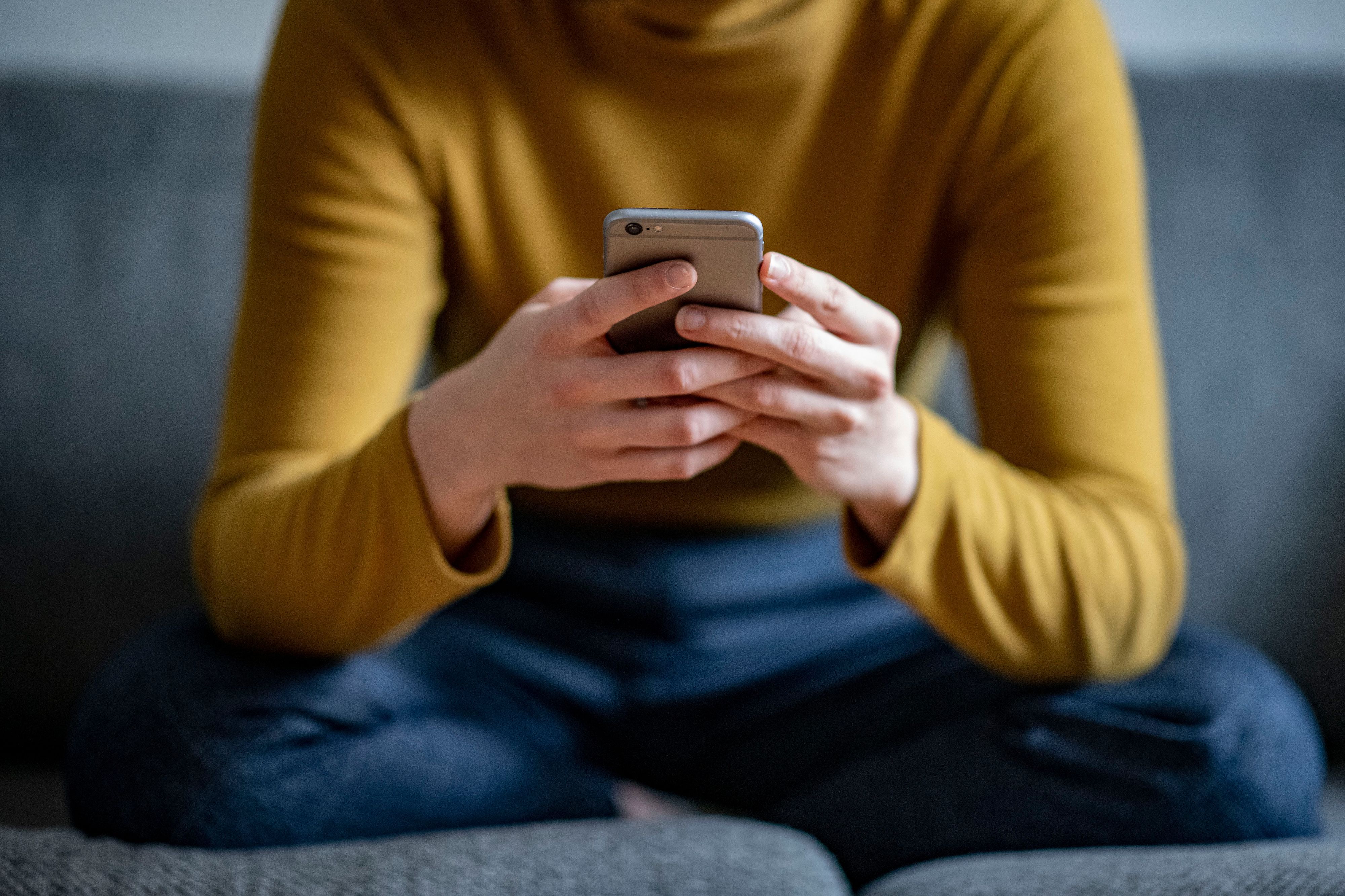 ARCHIV - 24.04.2021, Berlin: ILLUSTRATION - Eine junge Frau hält ein Smartphone in der Hand. (gestellte Szene) (zu dpa: «Umfrage: Smartphone-Nebenwirkungen von Ablenkung bis Schmerzen») Foto: Fabian Sommer/dpa +++ dpa-Bildfunk +++