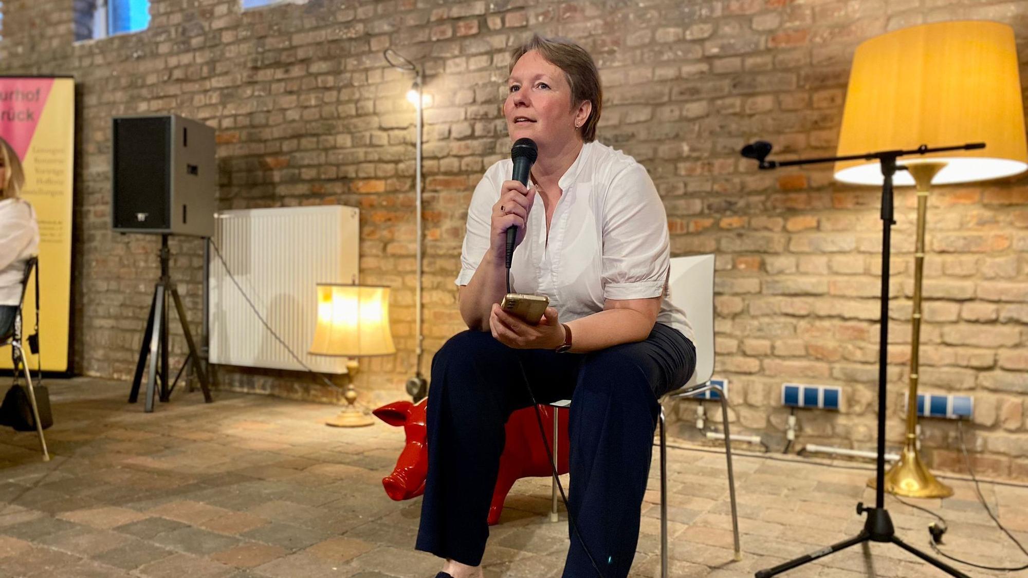 Anne Klöters sitzt auf einem Stuhl und trägt Gedichte vor.