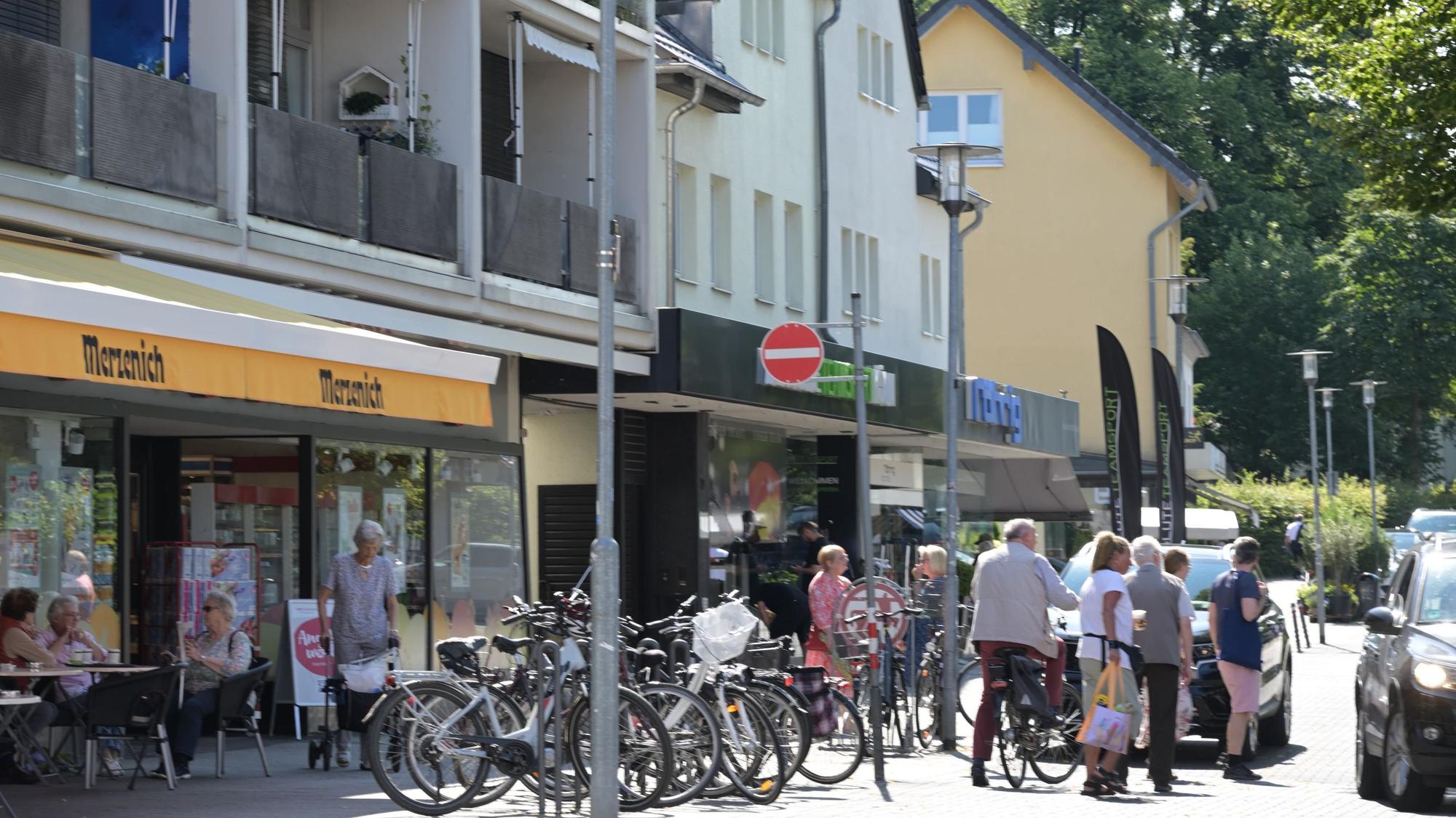 Menschen gehen über die Straße oder an den Geschäften vorbei.